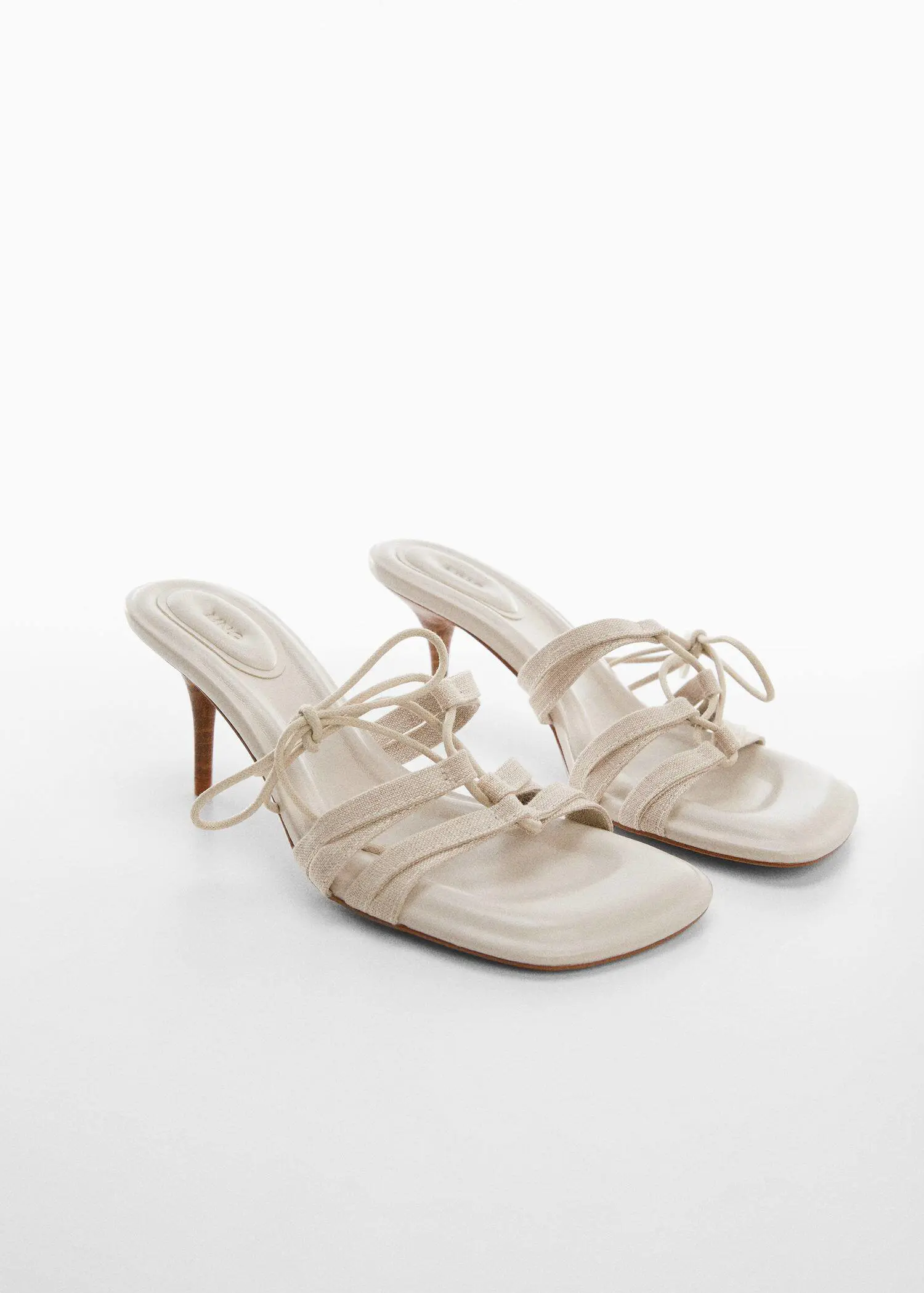 Mango Bow heel sandals. a pair of white high heeled sandals on a white surface. 