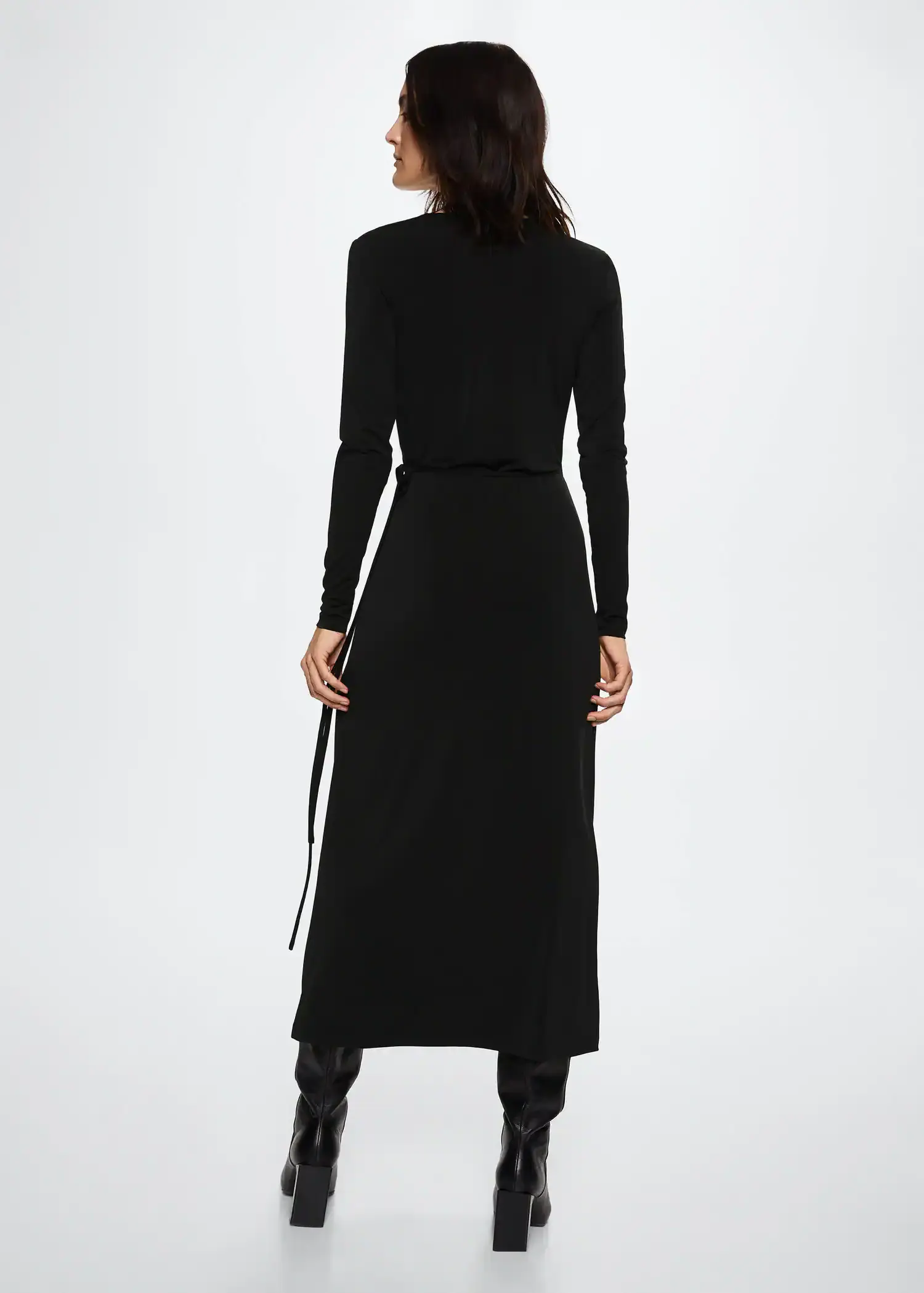 Mango Knotted wrap dress. a woman in a black dress standing in front of a white wall. 