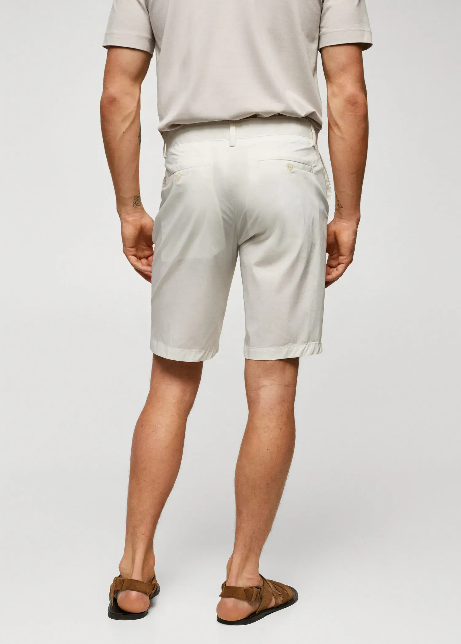 Mango Cotton pleated Bermuda shorts. a man in white shorts and a white shirt. 