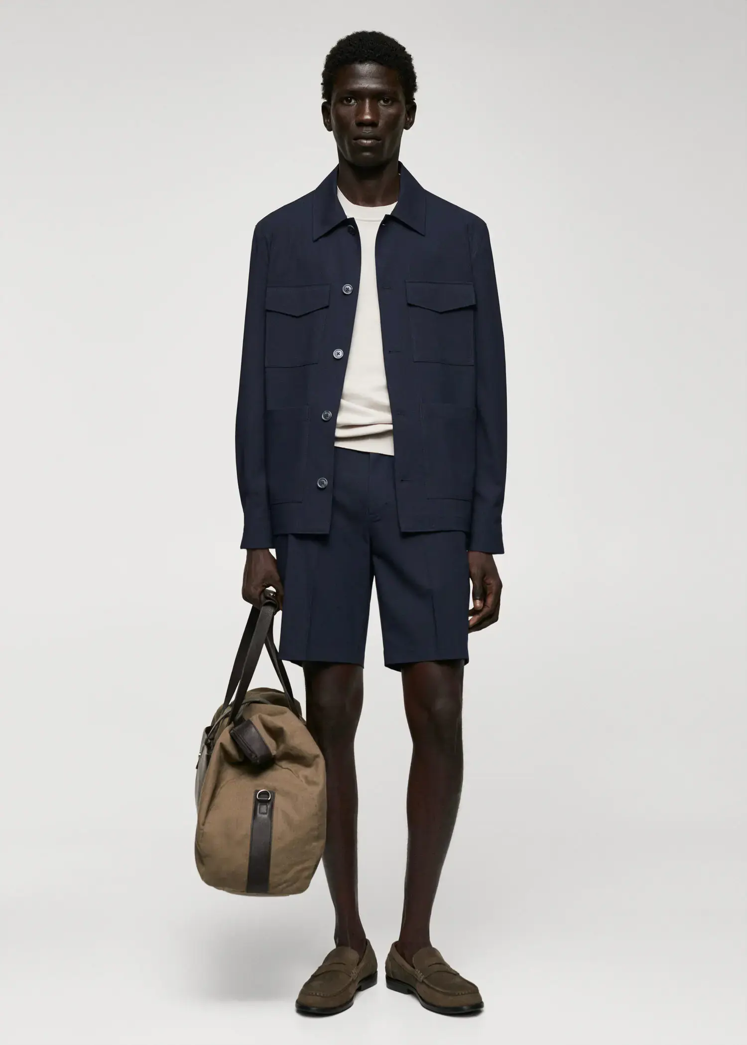 Mango Lightweight pocket jacket. a man in shorts and a jacket holding a bag. 