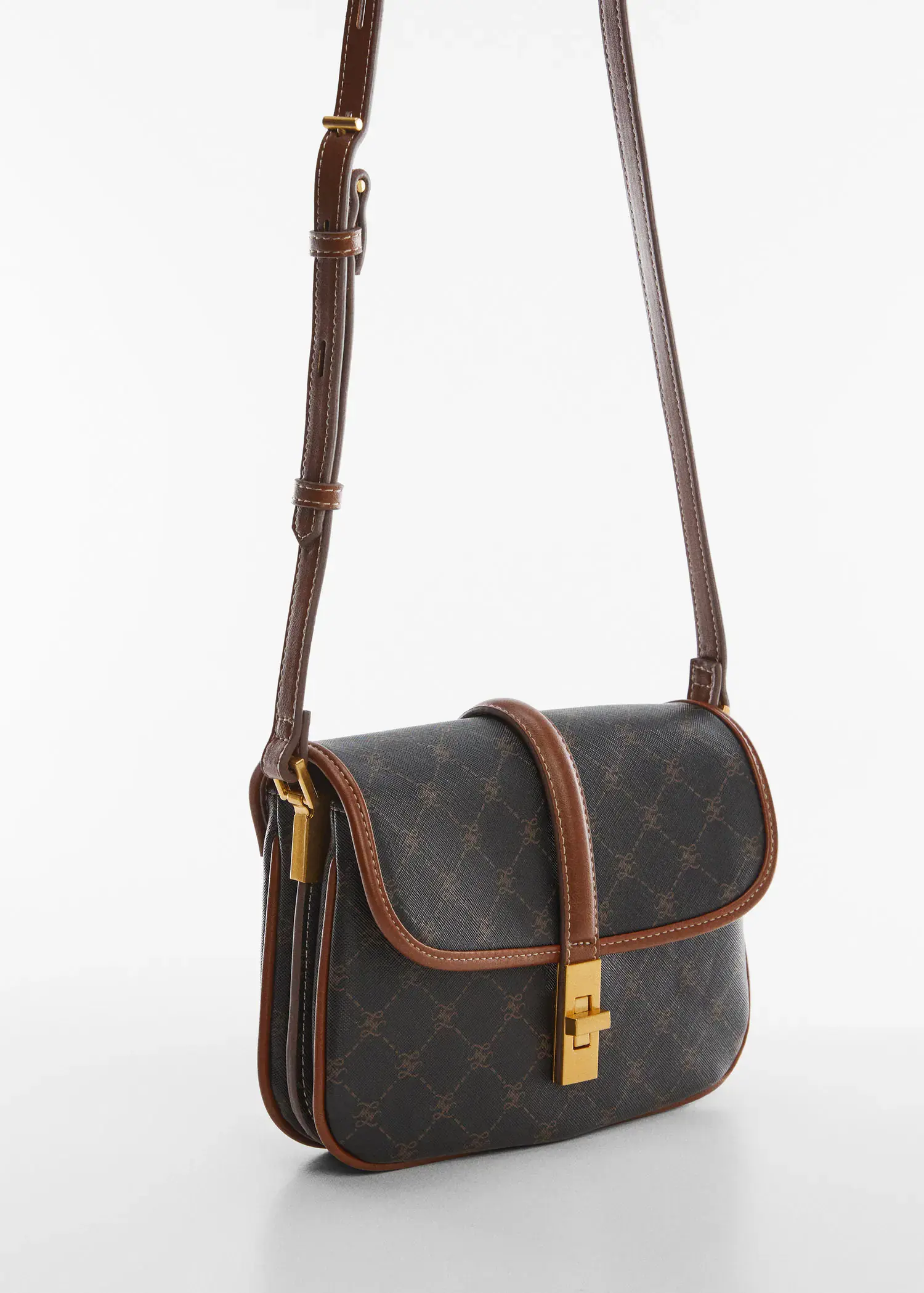 Mango Shoulder bag with printed logo. a brown and black purse is on a table. 