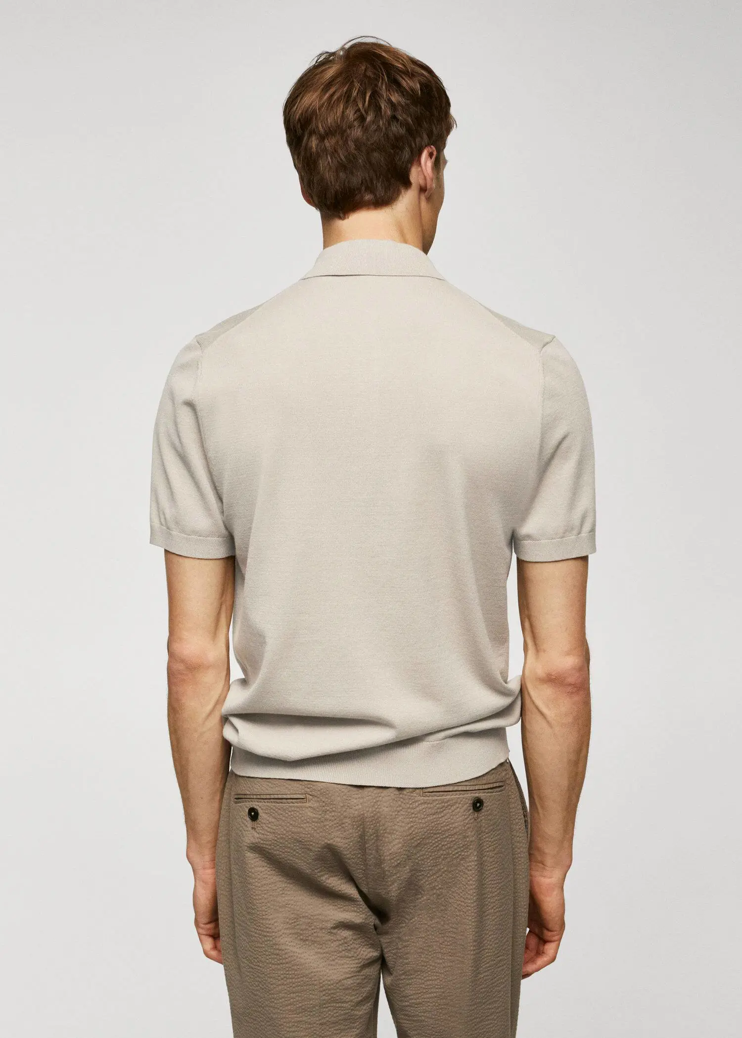 Mango Fine-knit polo shirt. a man wearing a beige shirt and brown pants. 