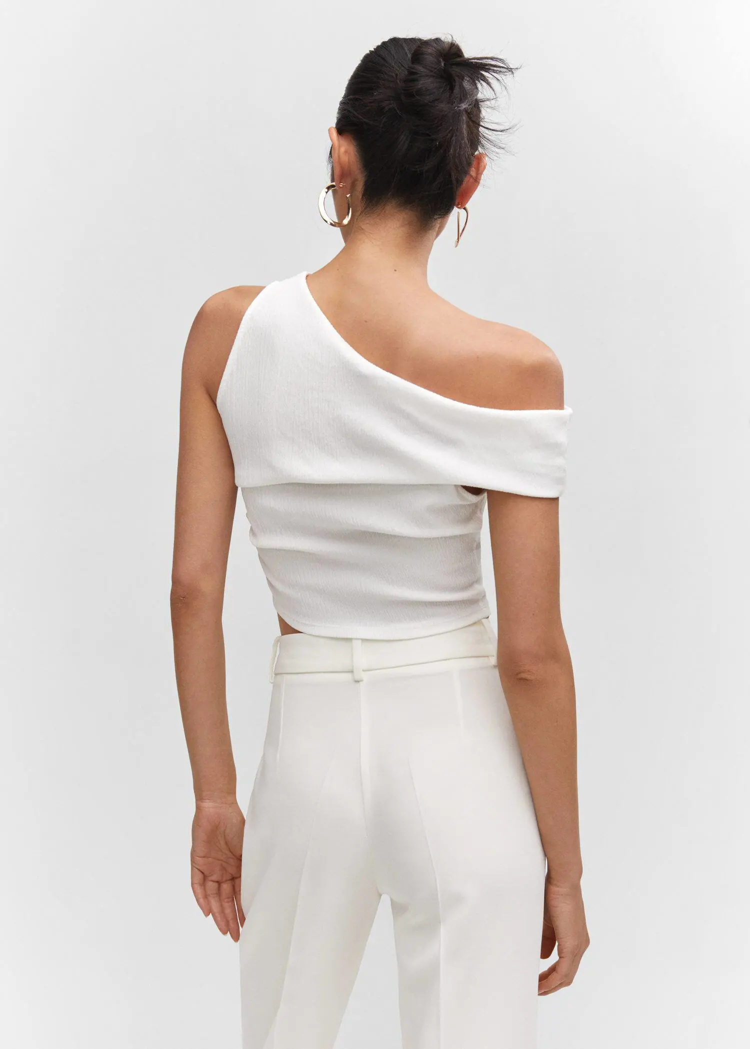 Mango Asymmetrical textured top. a woman wearing a white top and white pants. 