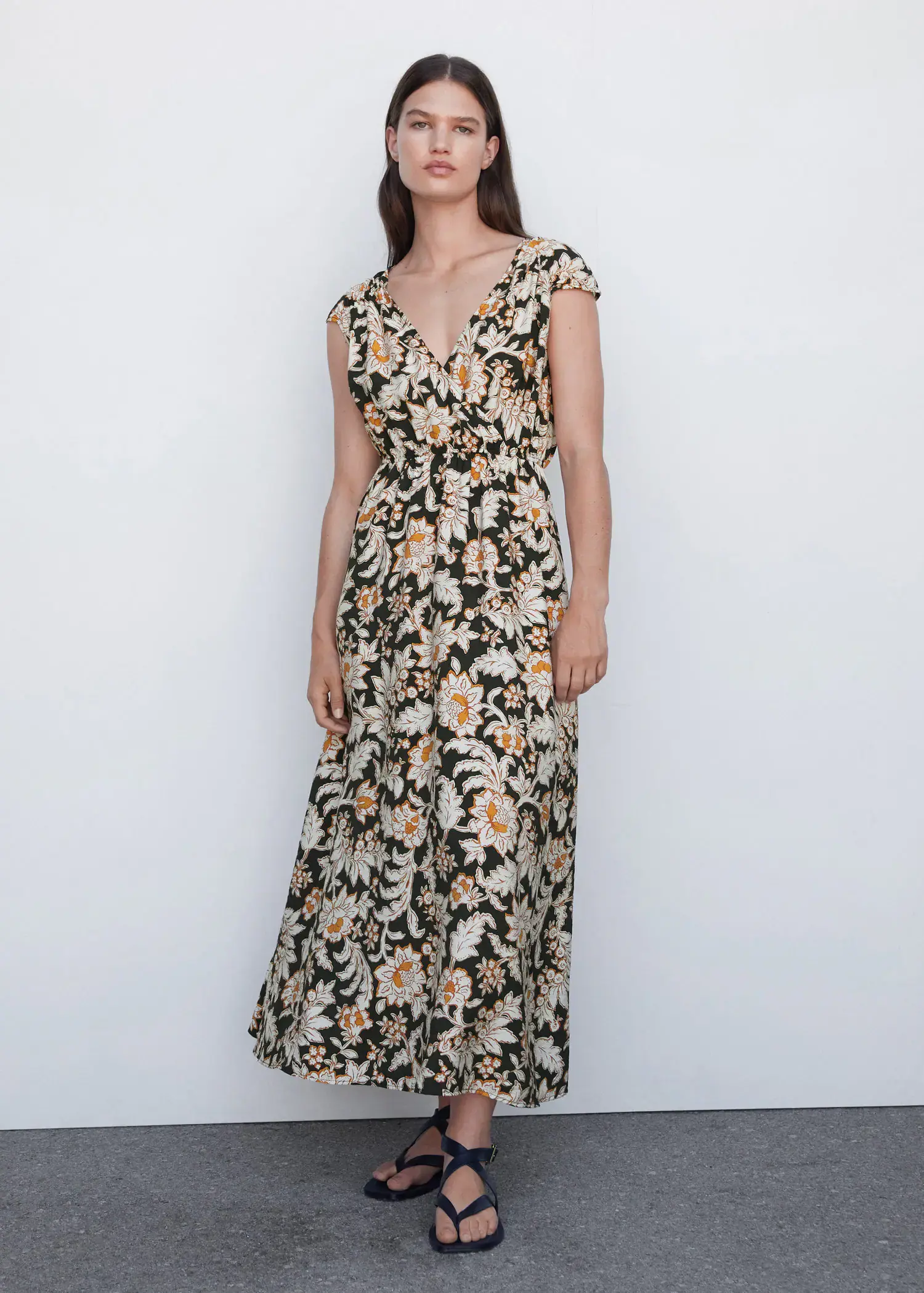 Mango Floral wrap neckline dress. a woman wearing a floral dress standing in front of a wall. 