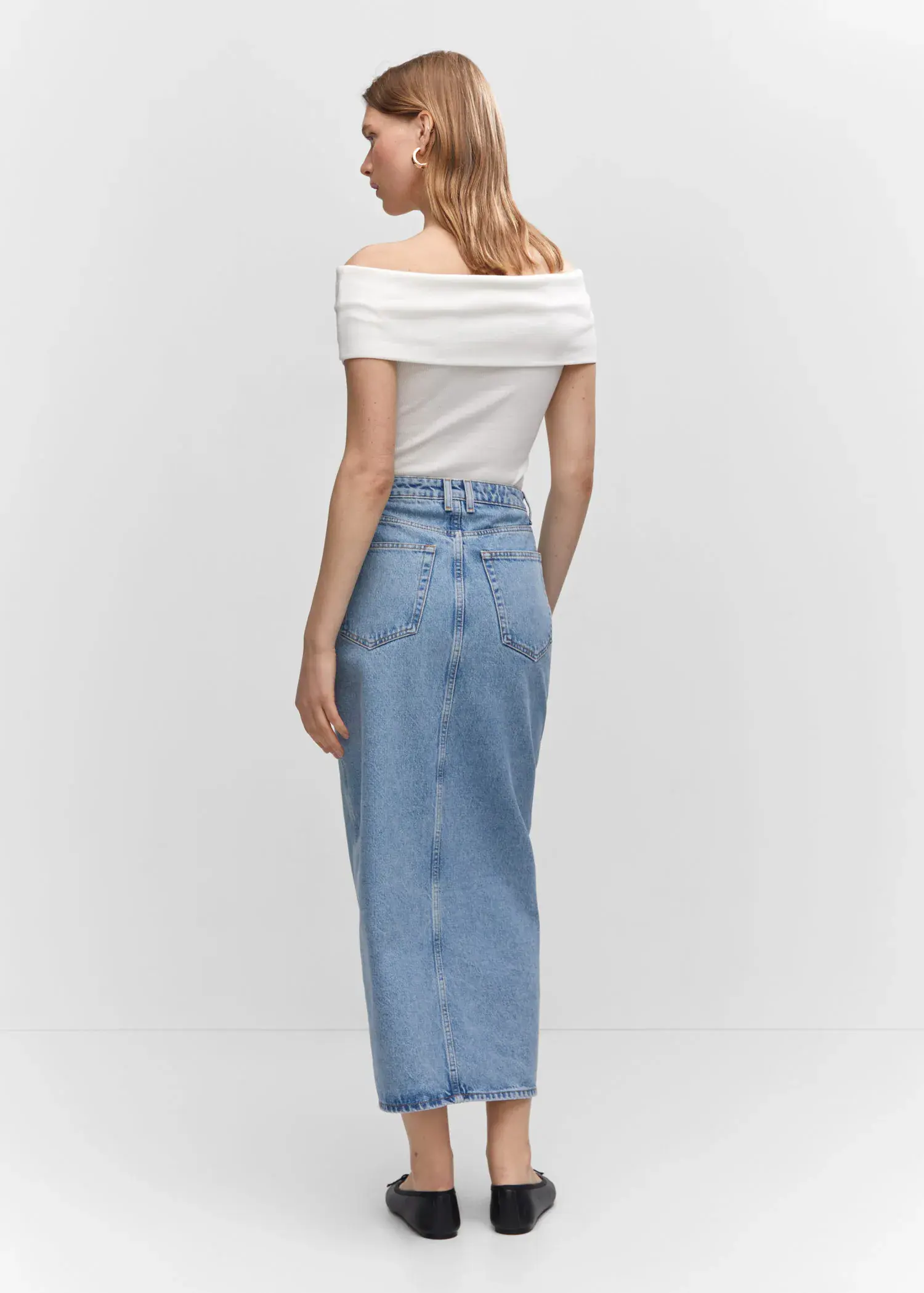 Mango Slit denim skirt. a woman in a white top and light blue jeans. 
