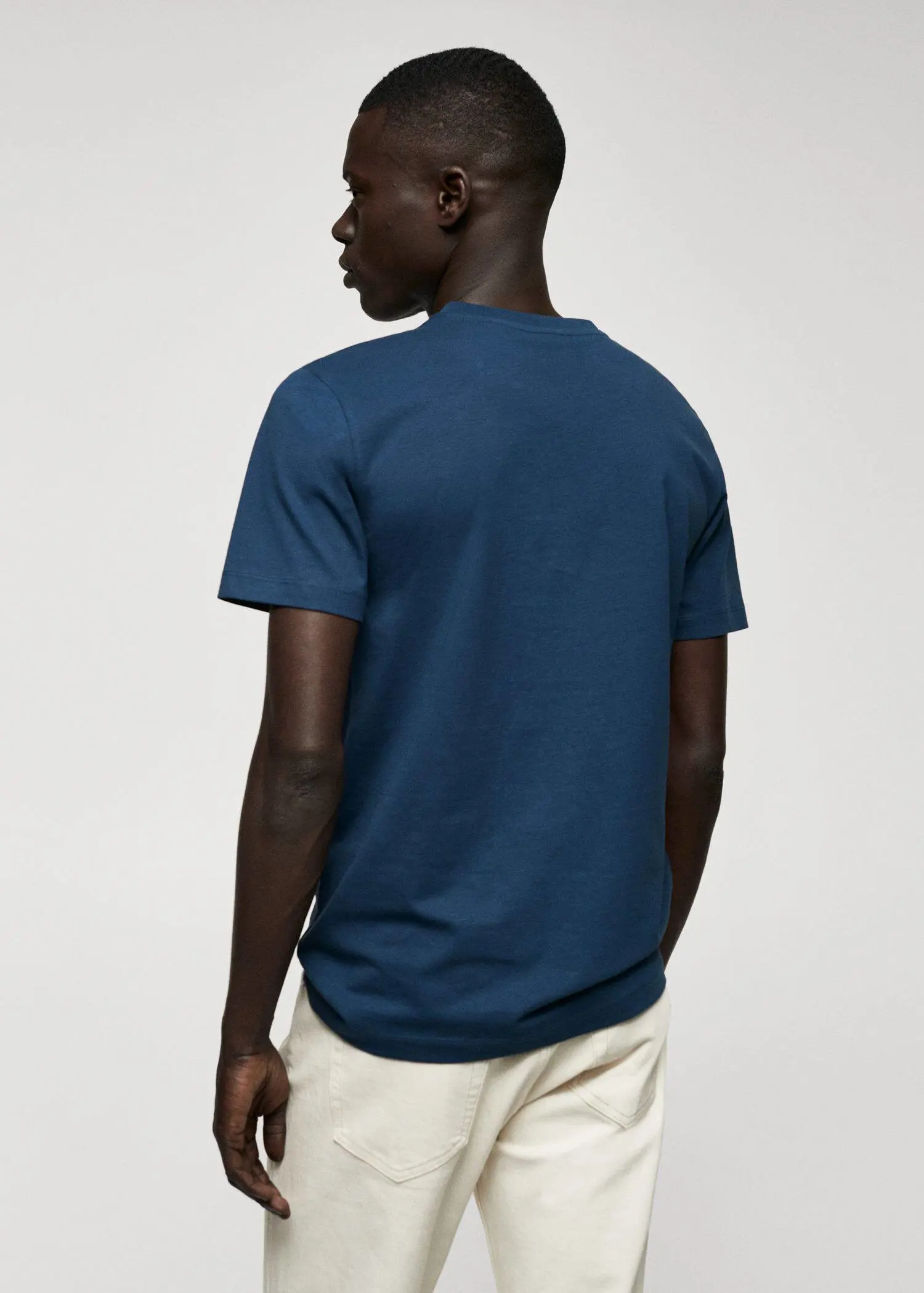 Mango Basic cotton V-neck T-shirt. a man wearing a blue shirt and white pants. 