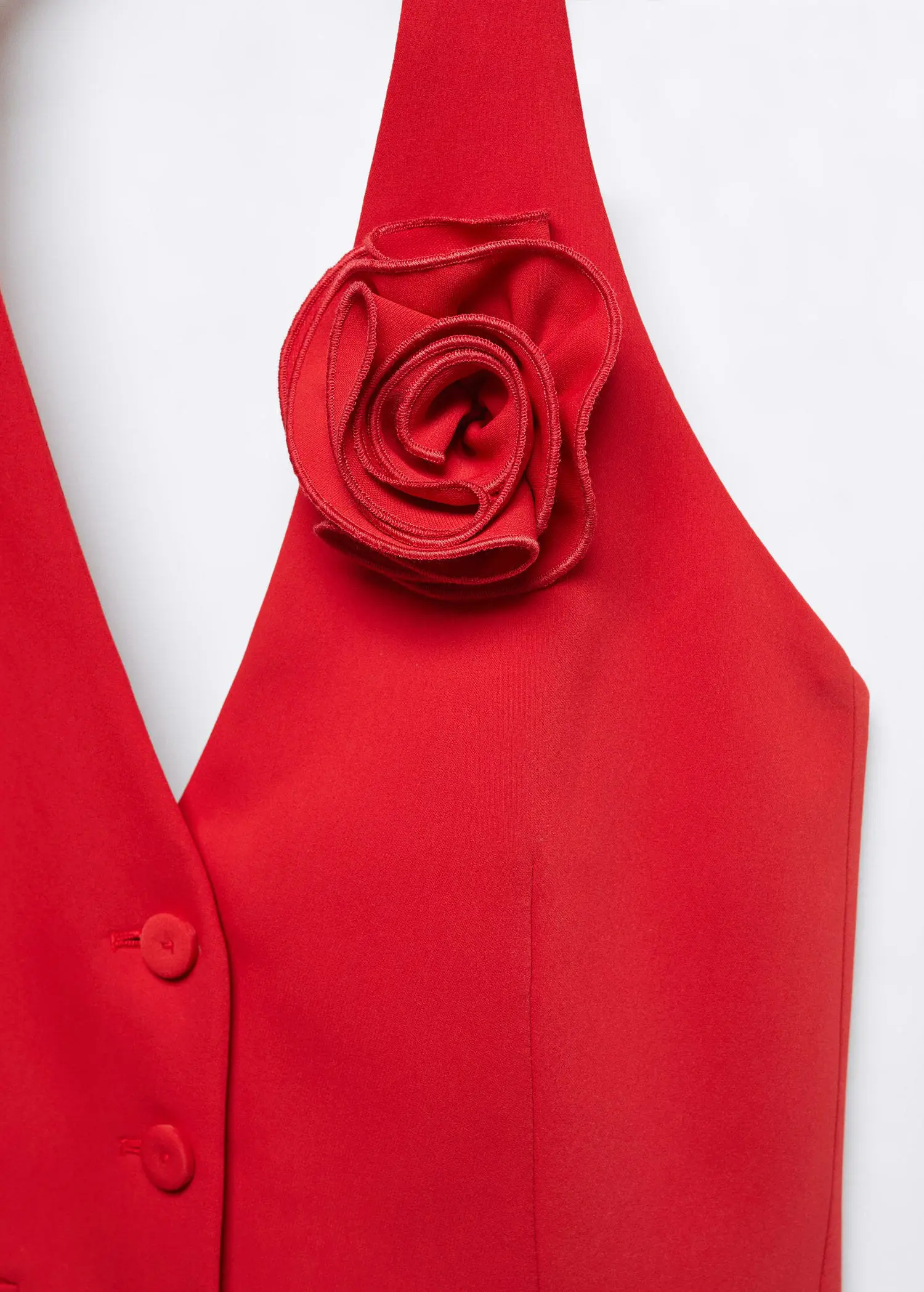 Mango Vest with floral appliqué . a close-up of a red vest with a flower on it. 