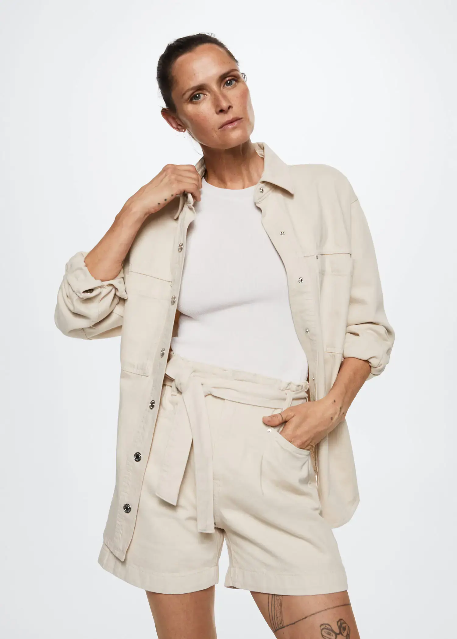 Mango Paperbag denim shorts. a woman wearing a white shirt and a beige jacket. 