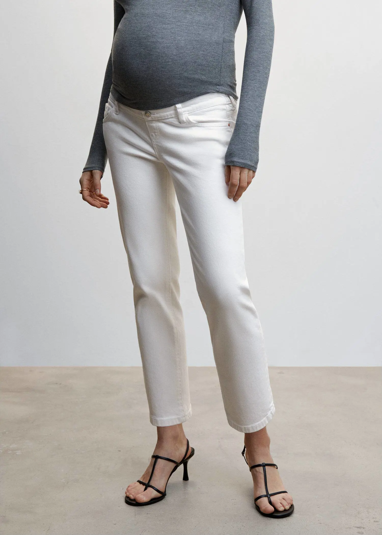 Mango Maternity Straight Jeans. a woman standing in a room wearing white pants. 