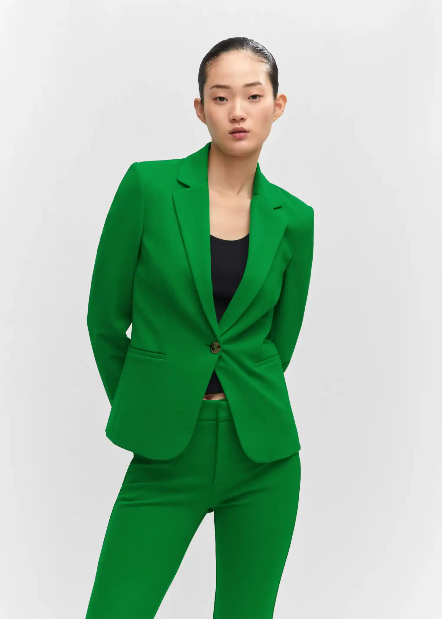 Mango Fitted jacket with blunt stitching. a woman in a green suit poses for a picture. 