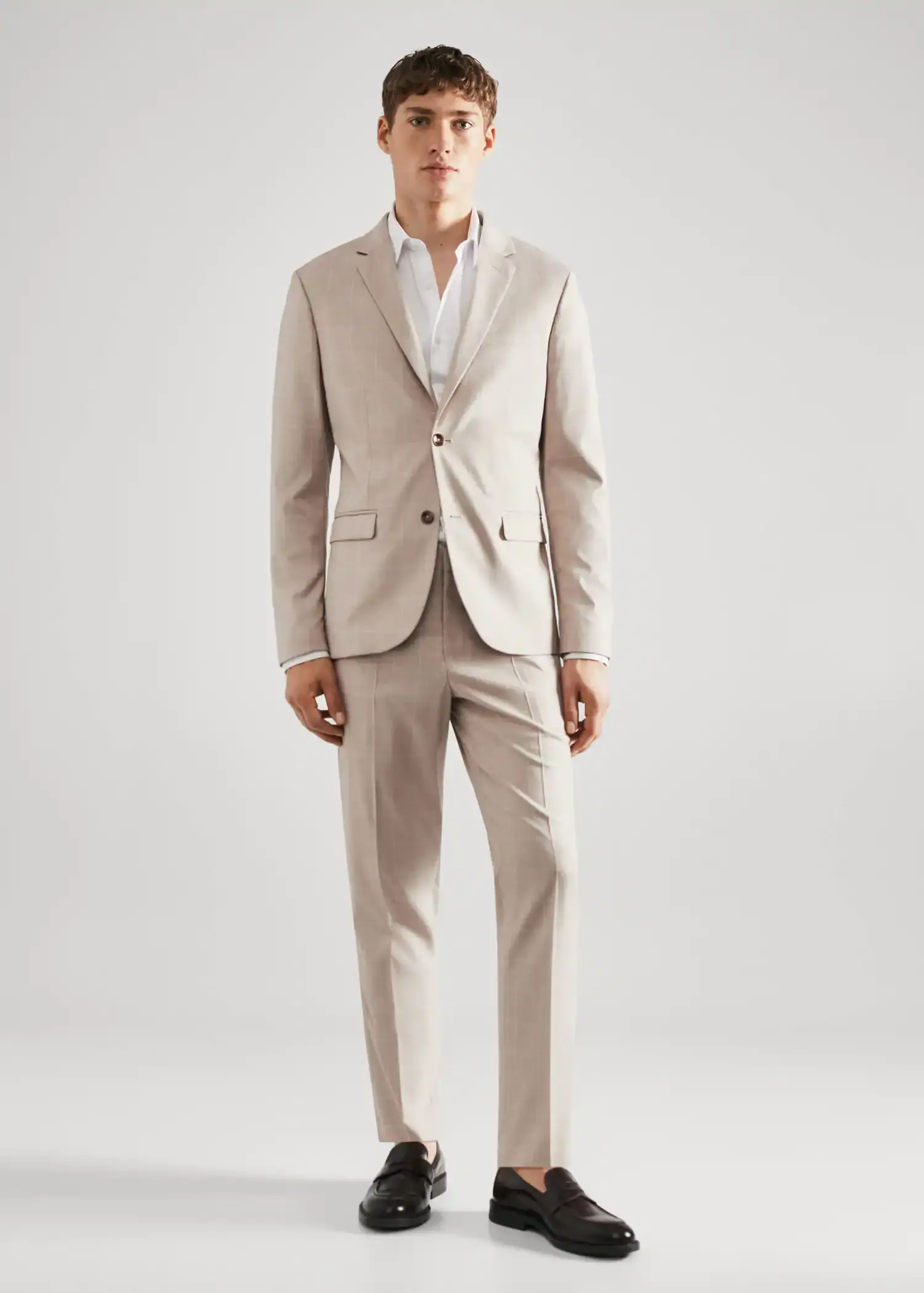Mango Super slim-fit Tailored check trousers. a man in a suit standing in front of a white wall. 