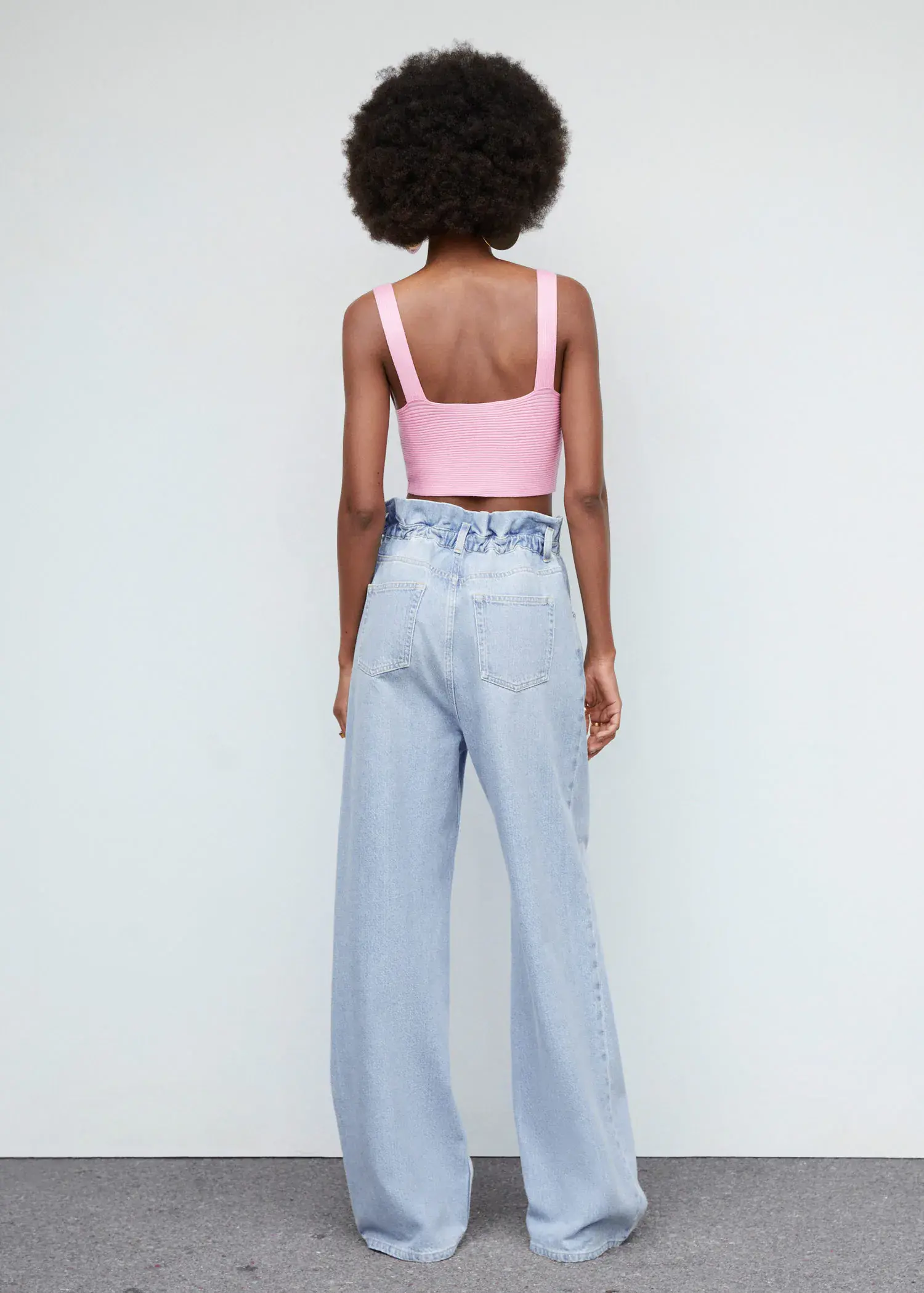 Mango Waist straight Slouchy jeans. a woman wearing a pink crop top and light blue jeans. 
