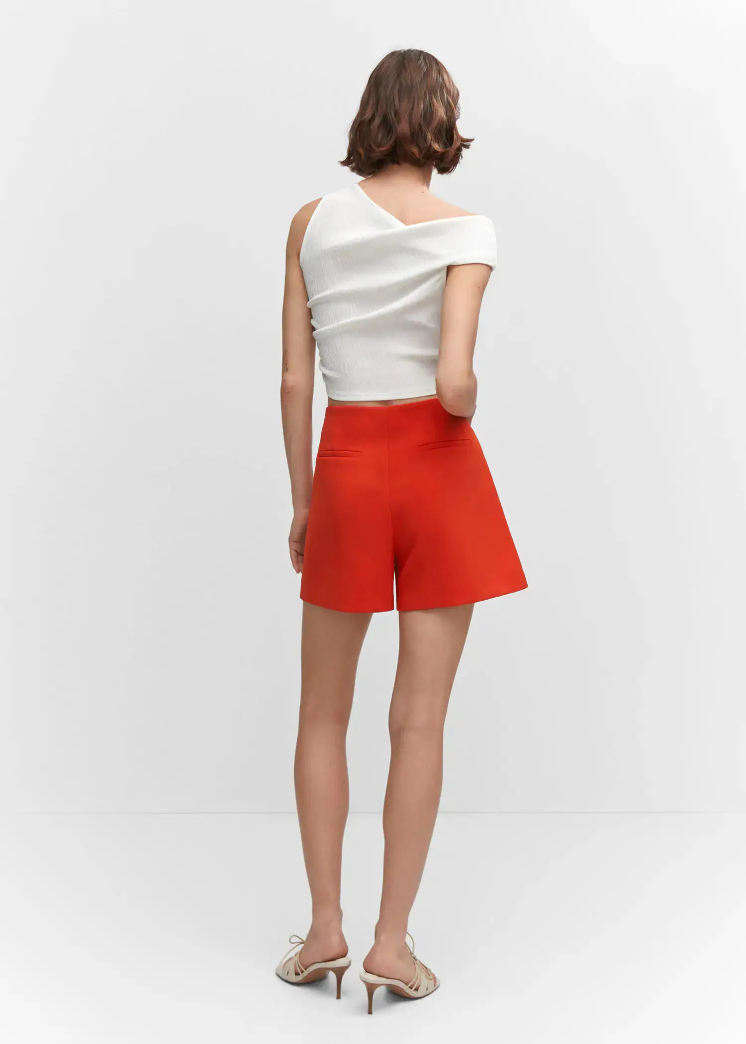 Mango High-waist straight shorts. a woman wearing a white top and red shorts. 