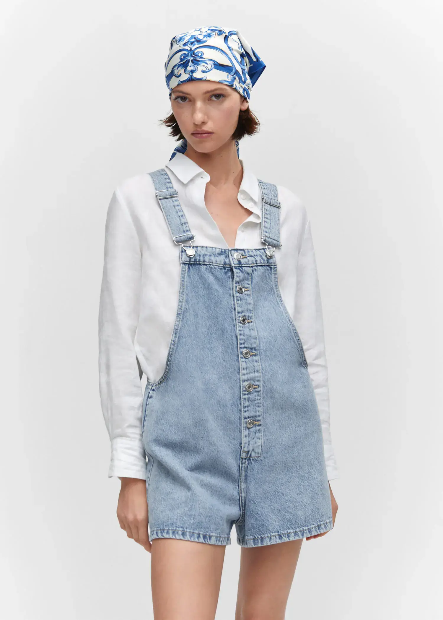 Mango Denim button-down dungarees. a woman wearing a white shirt and a denim overalls. 