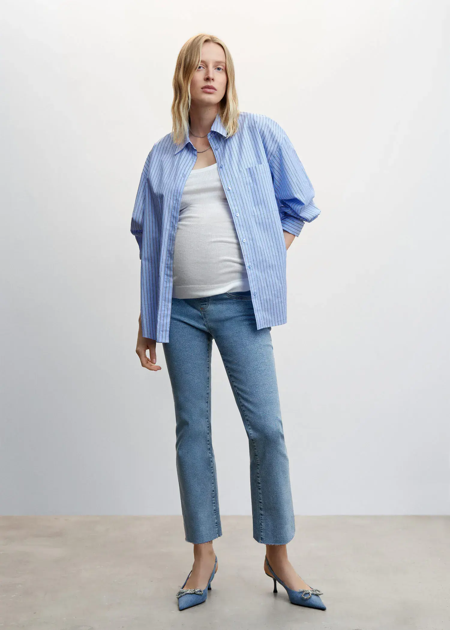 Mango Maternity flared cropped jeans. a pregnant woman wearing jeans and a blue shirt. 