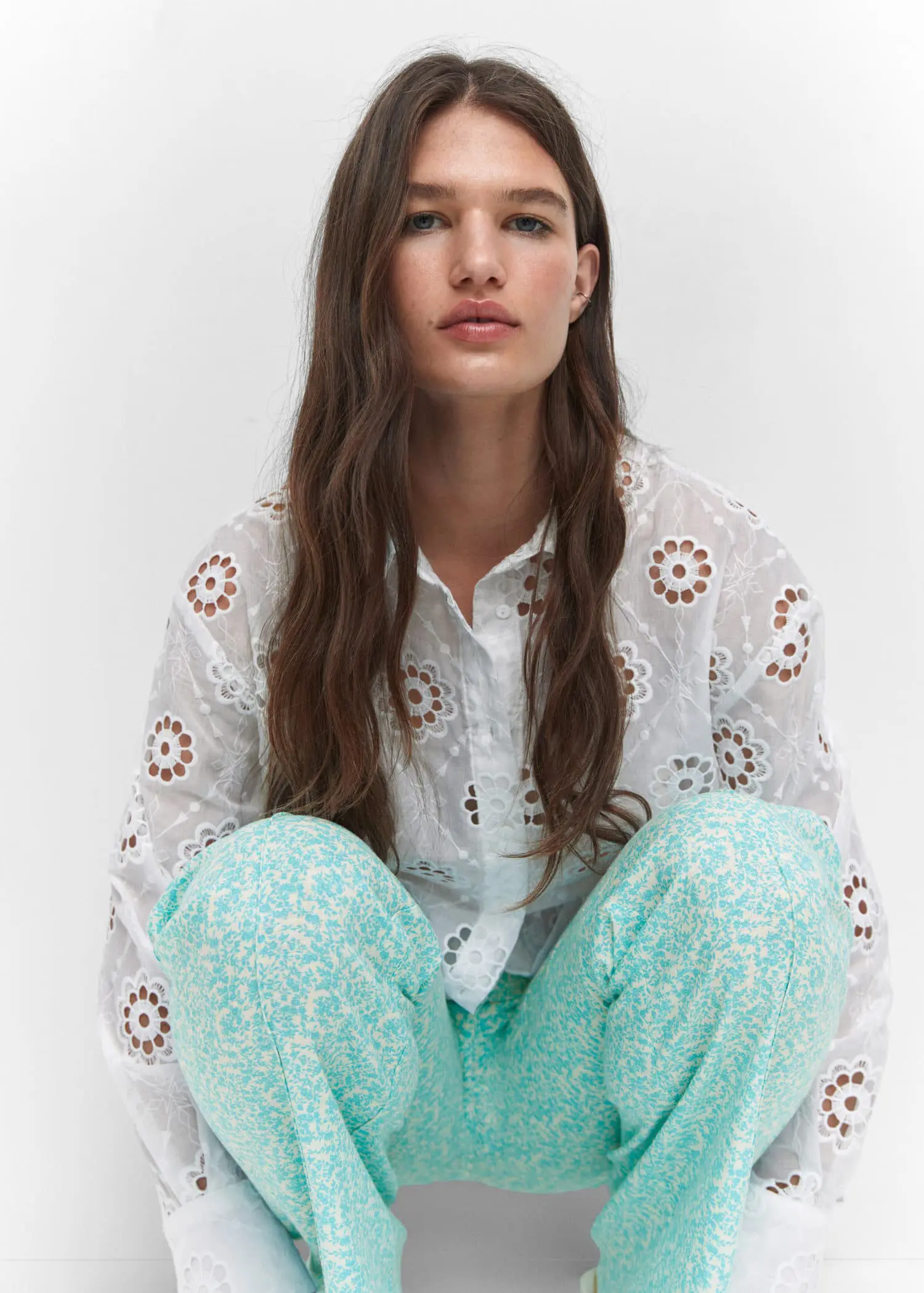 Mango Embroidered openwork shirt. a woman sitting on the ground wearing a white shirt. 