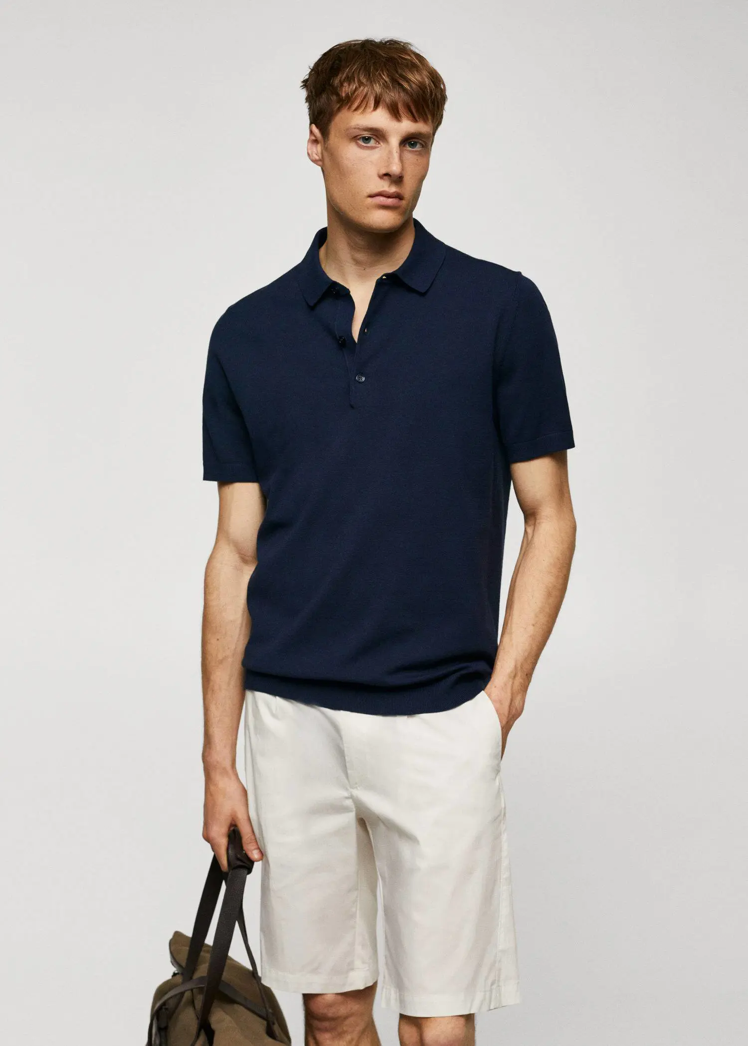 Mango Fine-knit polo shirt. a man wearing a black polo shirt and white pants. 