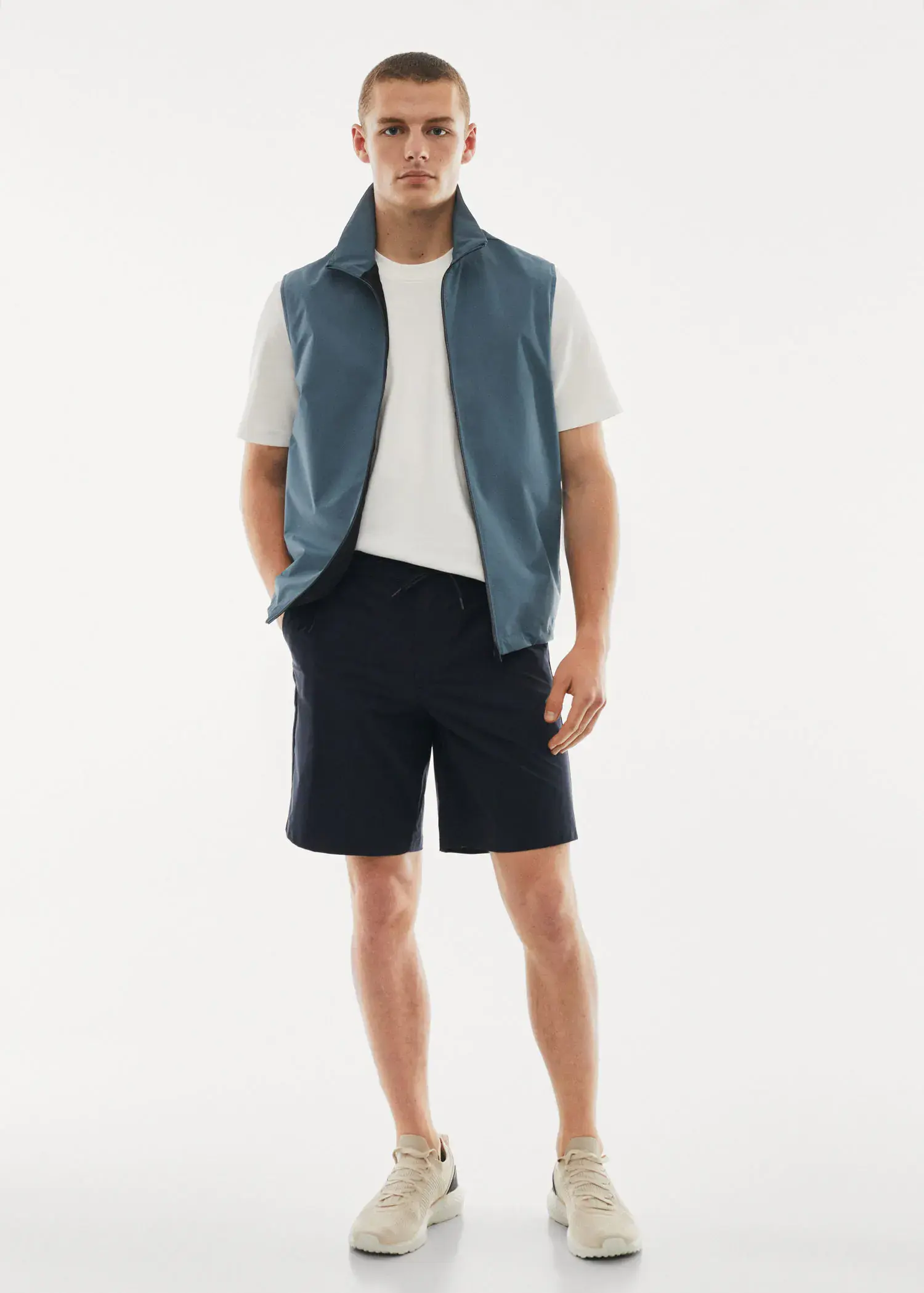 Mango Technical fabric bermuda shorts with drawstring. a young man wearing a blue vest and black shorts. 