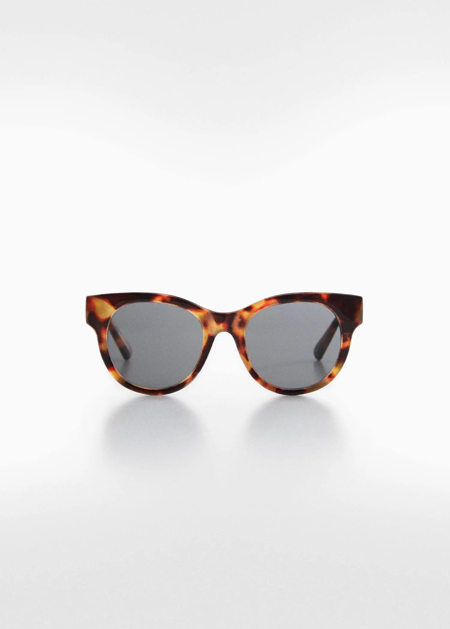 Mango Tortoiseshell sunglasses. a pair of sunglasses sitting on top of a white table. 