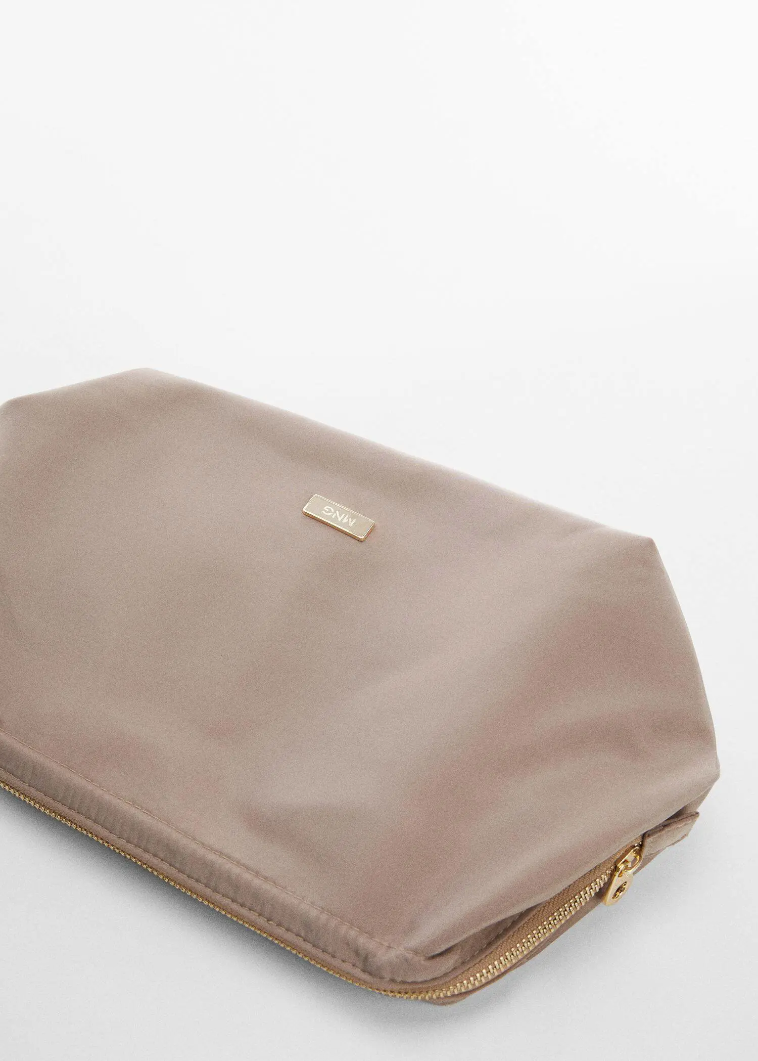 Mango Zipped nylon cosmetics bag. a close-up of a beige cosmetic bag on a table. 