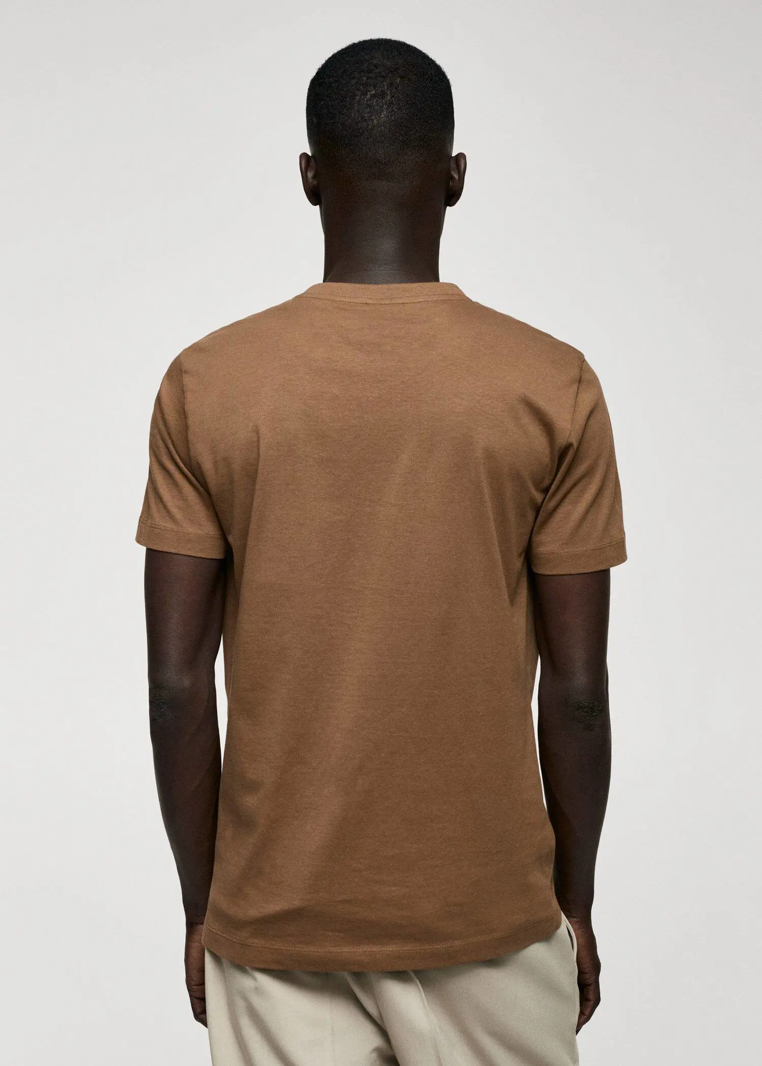 Mango Basic cotton V-neck T-shirt. a person wearing a brown t-shirt and a hat. 