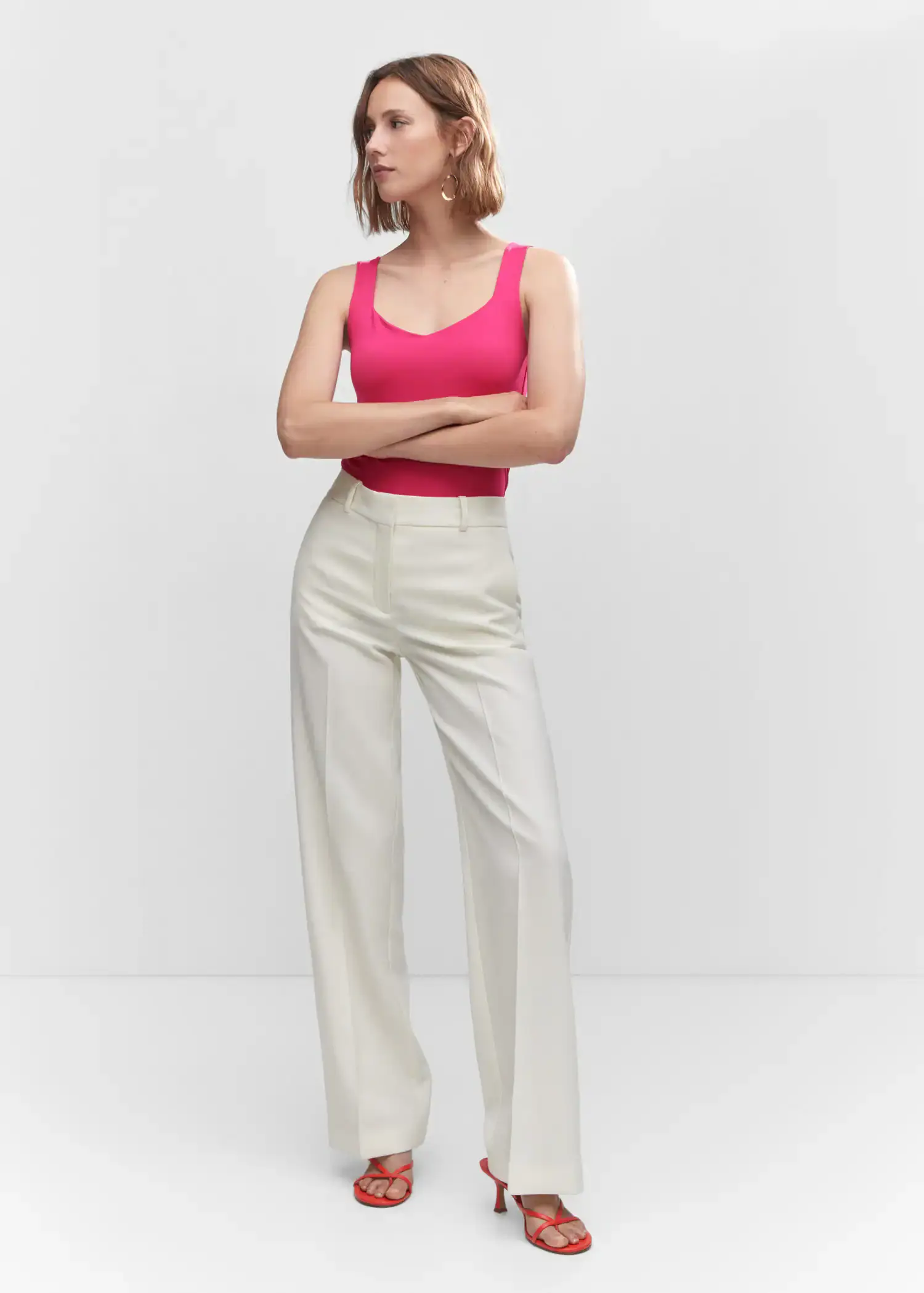 Mango Open elastic top. a woman in a pink top and white pants. 