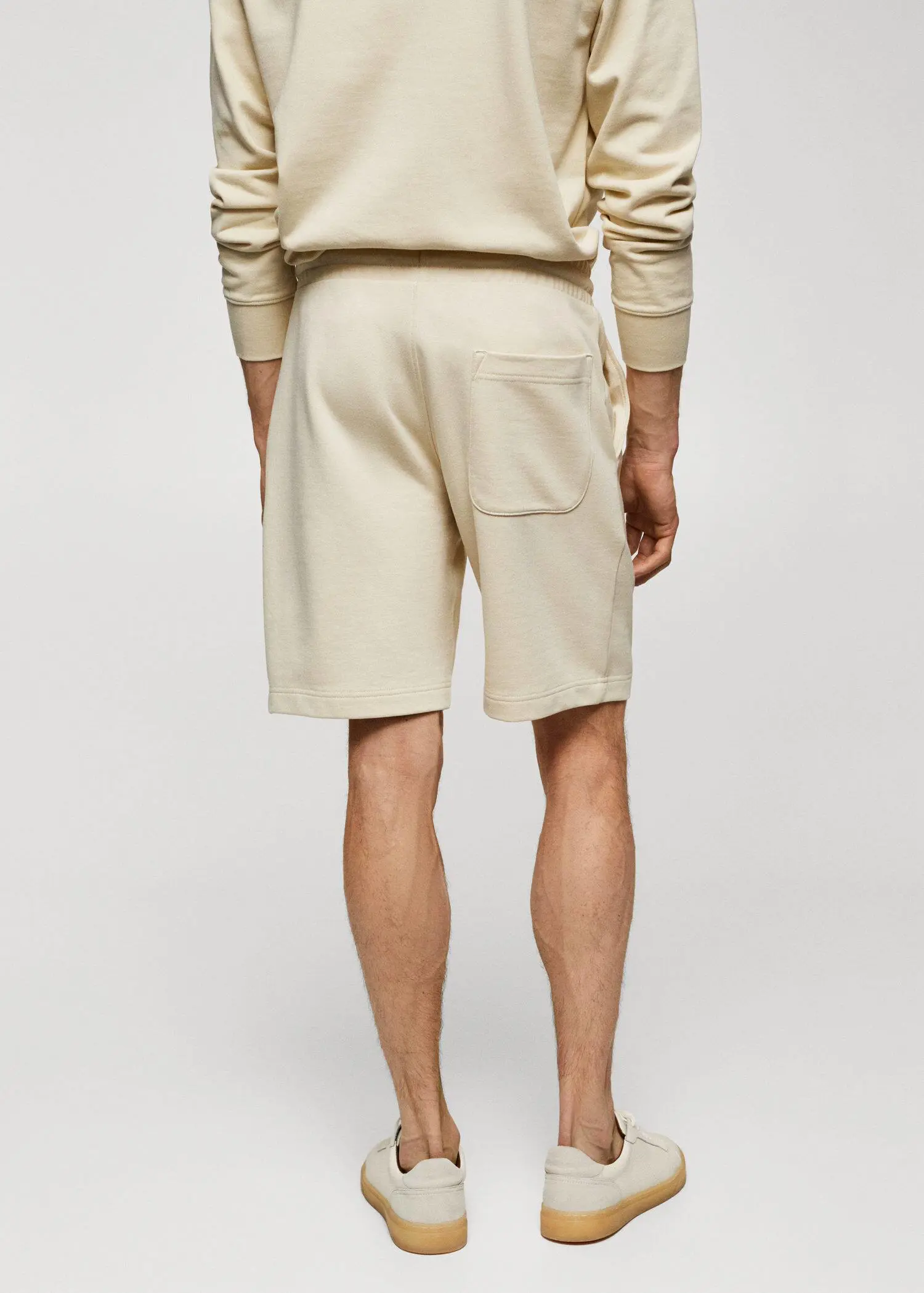 Mango Jogger cotton Bermuda shorts. a man in white shorts and a white sweater. 