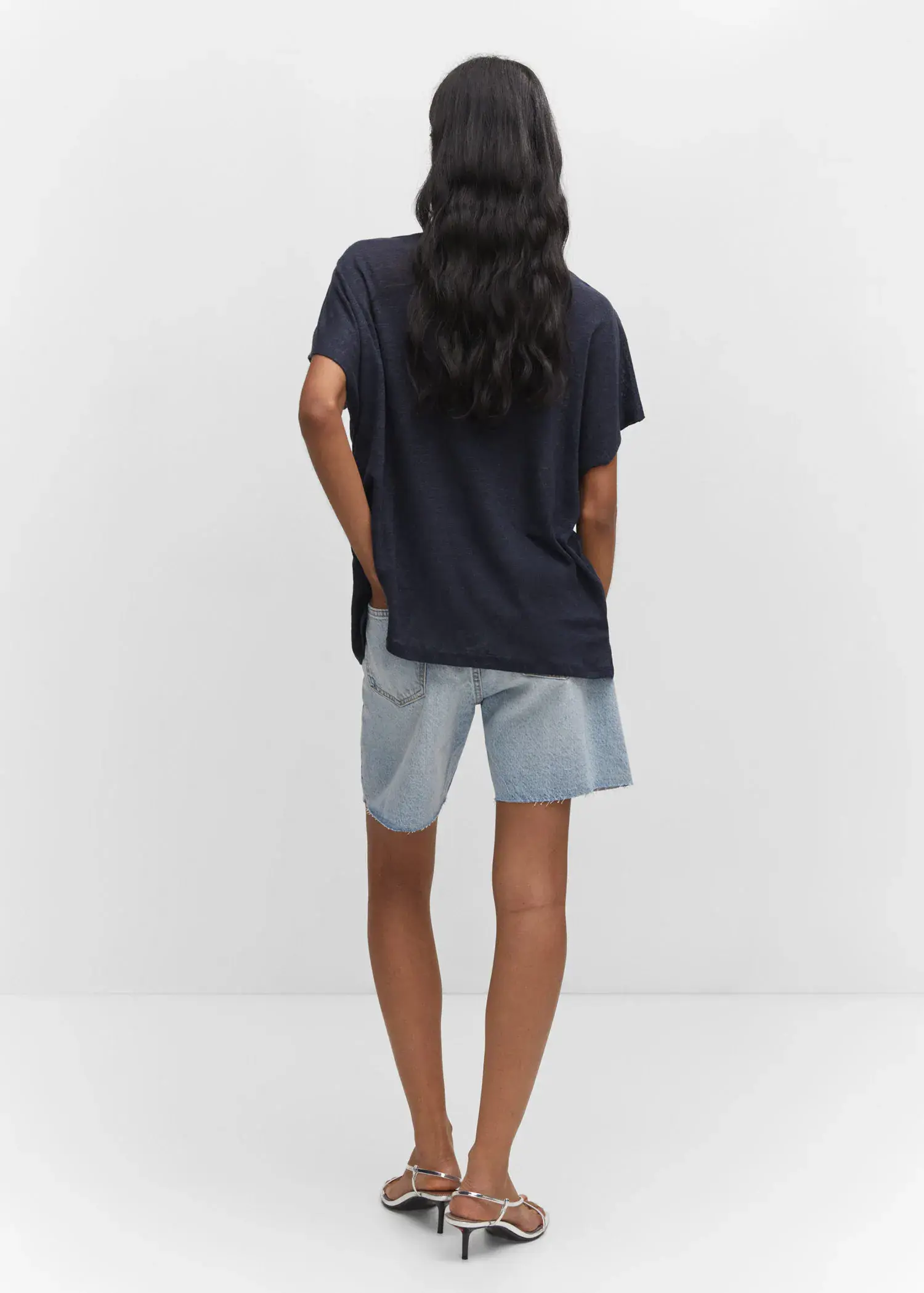 Mango Oversized linen t-shirt. a person standing with their hands in their pockets. 