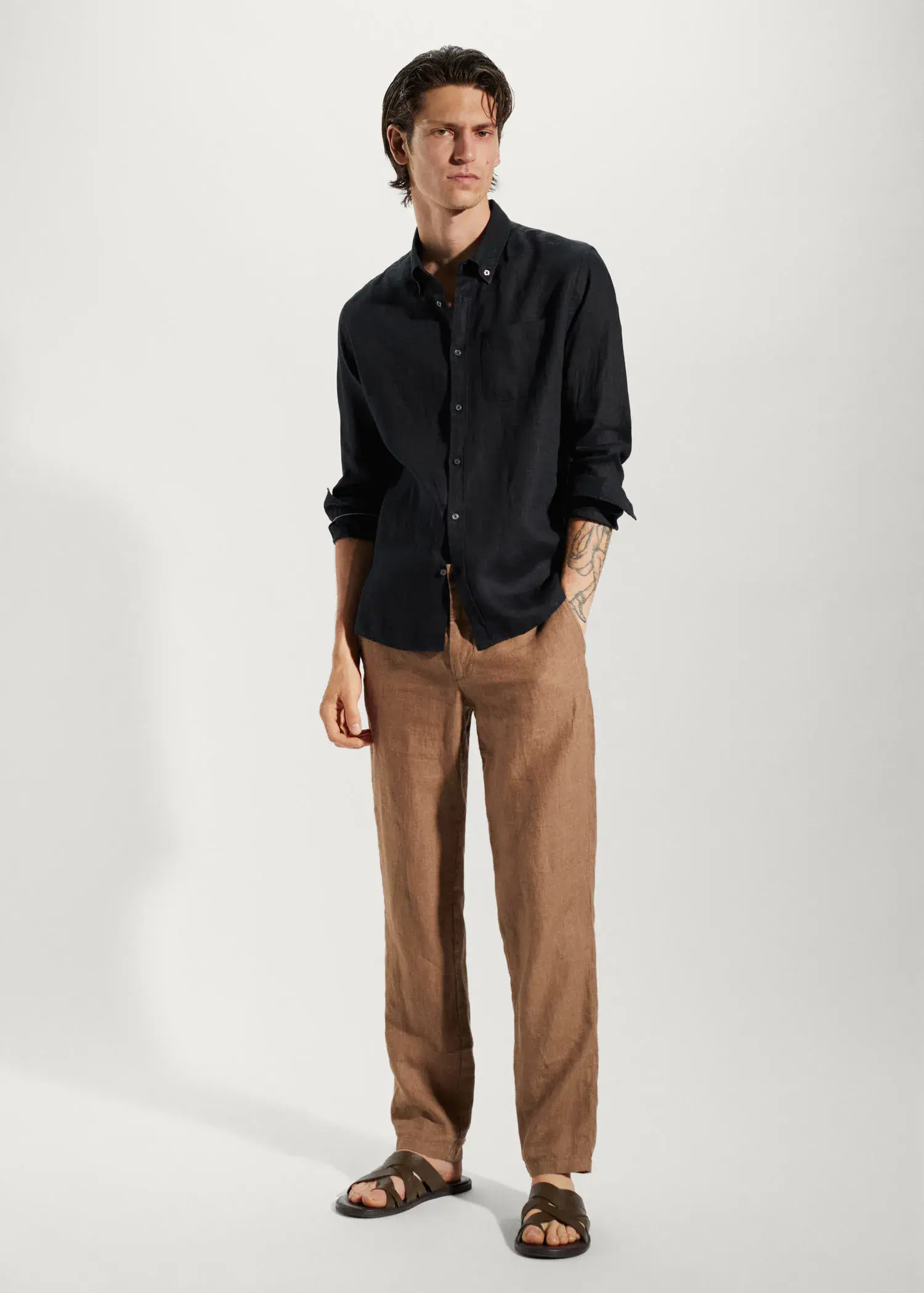Mango 100% linen slim-fit shirt. a man in a black shirt and brown pants. 