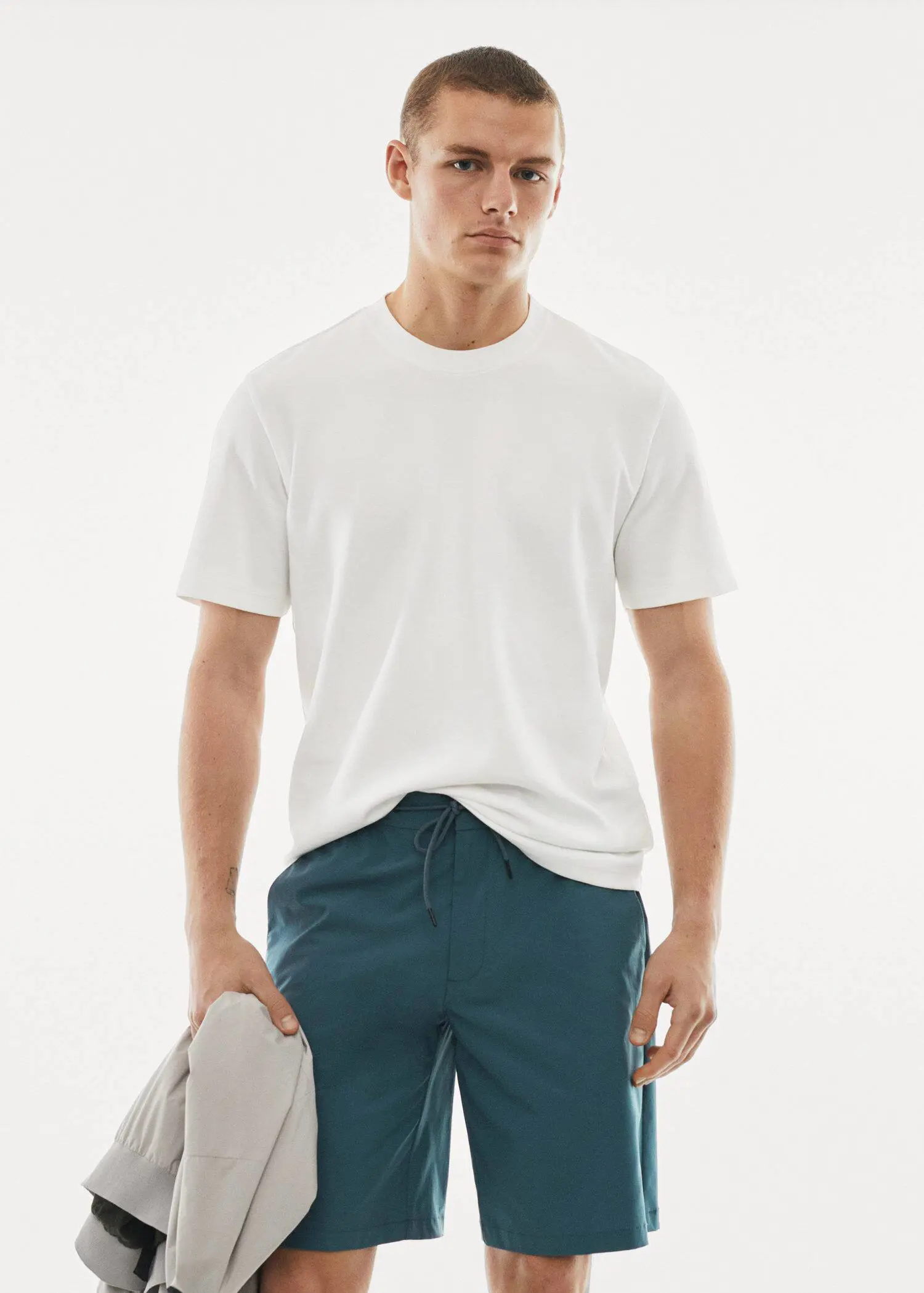 Mango Breathable cotton t-shirt. a man in white shirt and blue shorts holding a tennis racket. 