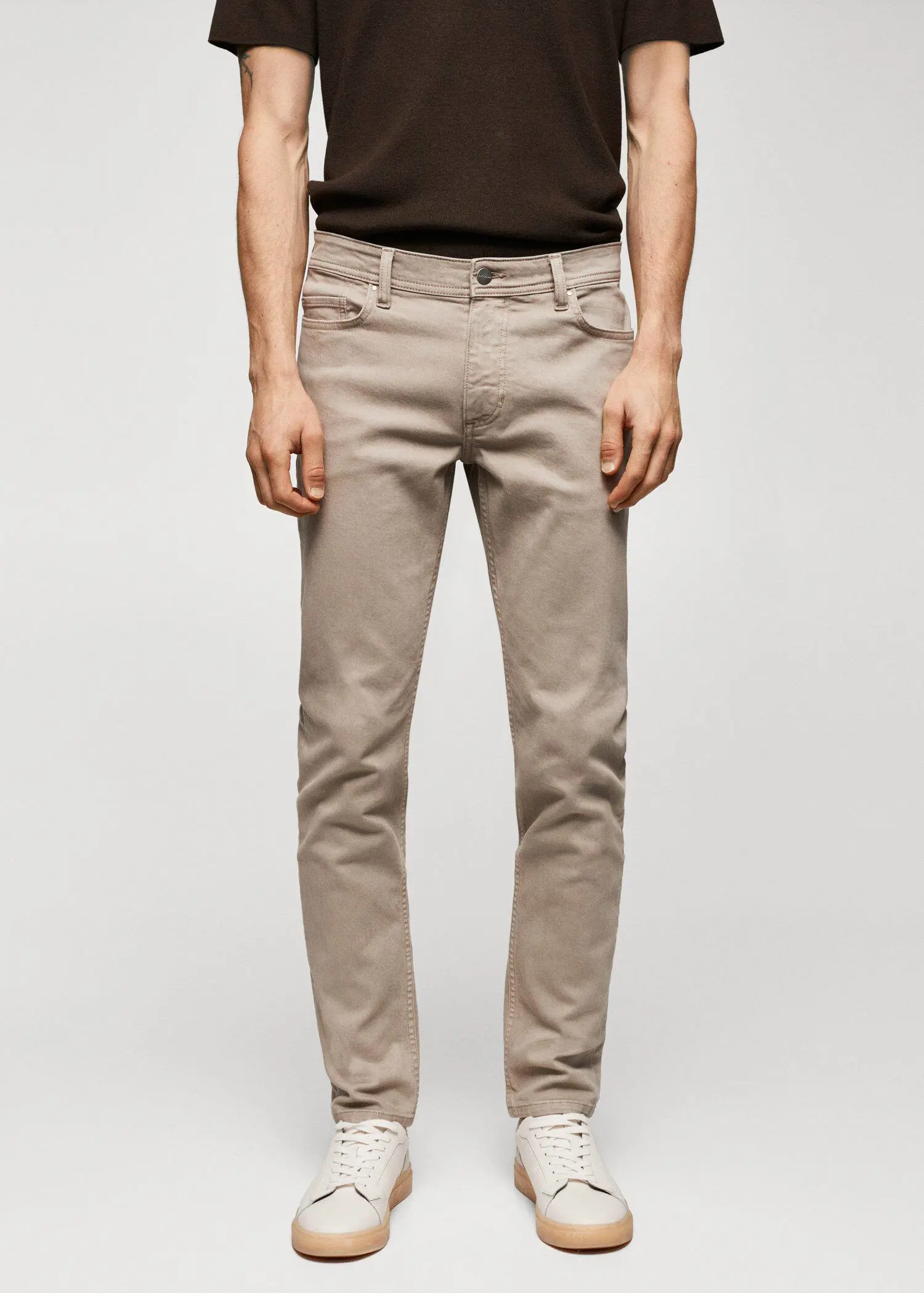 Mango Jan slim-fit jeans. a man in a black shirt and beige pants. 