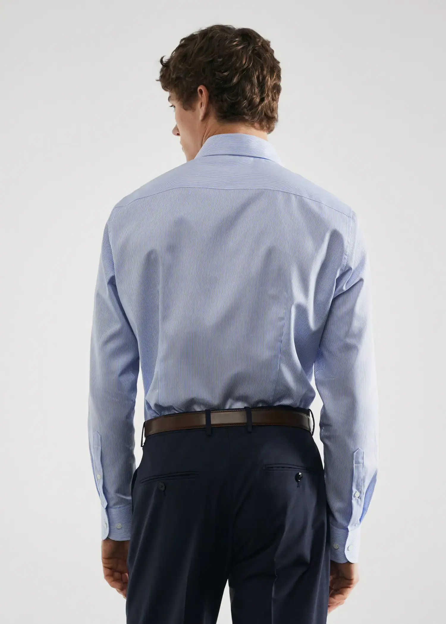 Mango Slim-fit twill pinstripe suit shirt. a man wearing a blue shirt and black pants. 