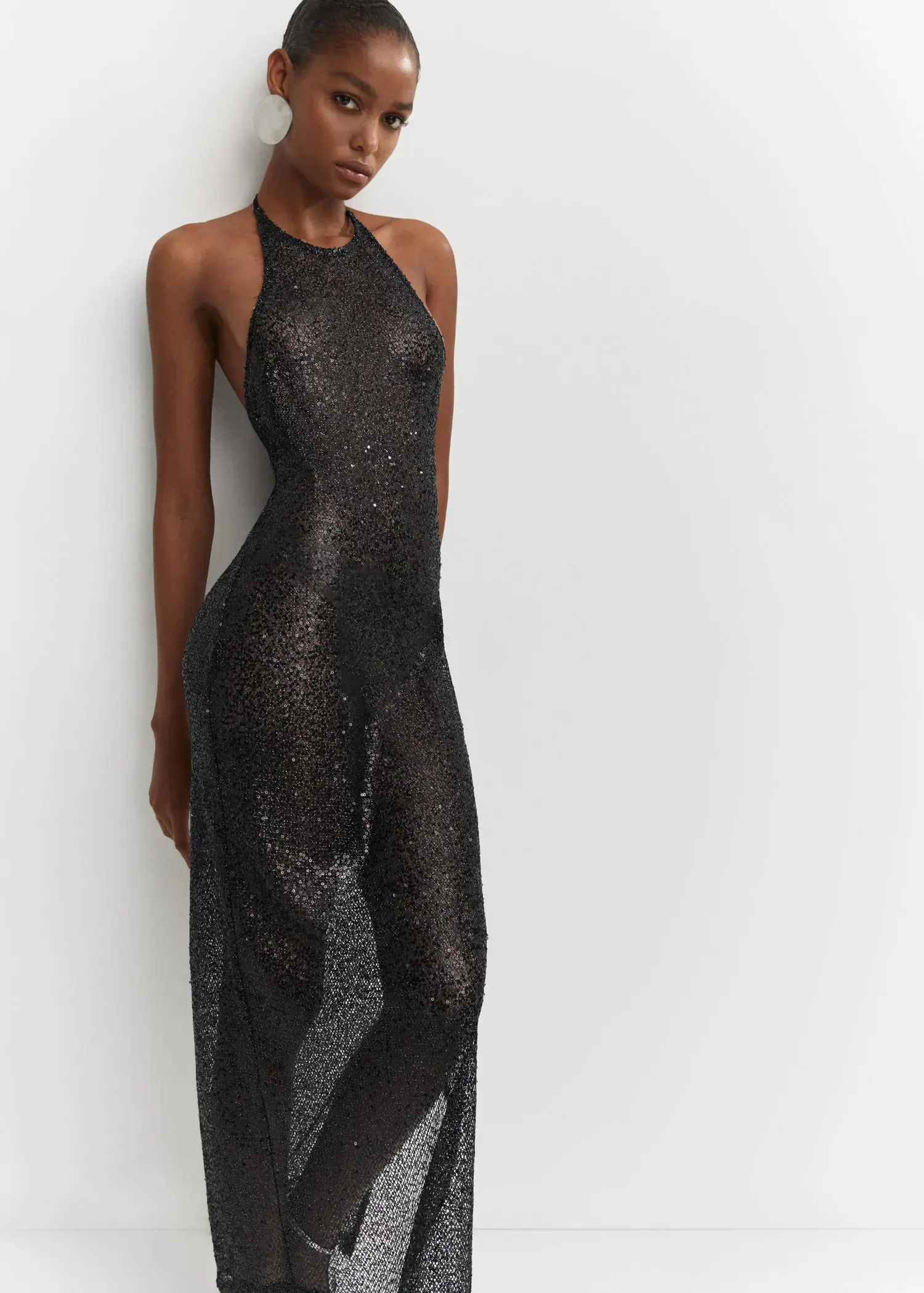 Mango Side slit sequined gown. a woman leaning against a wall wearing a dress. 