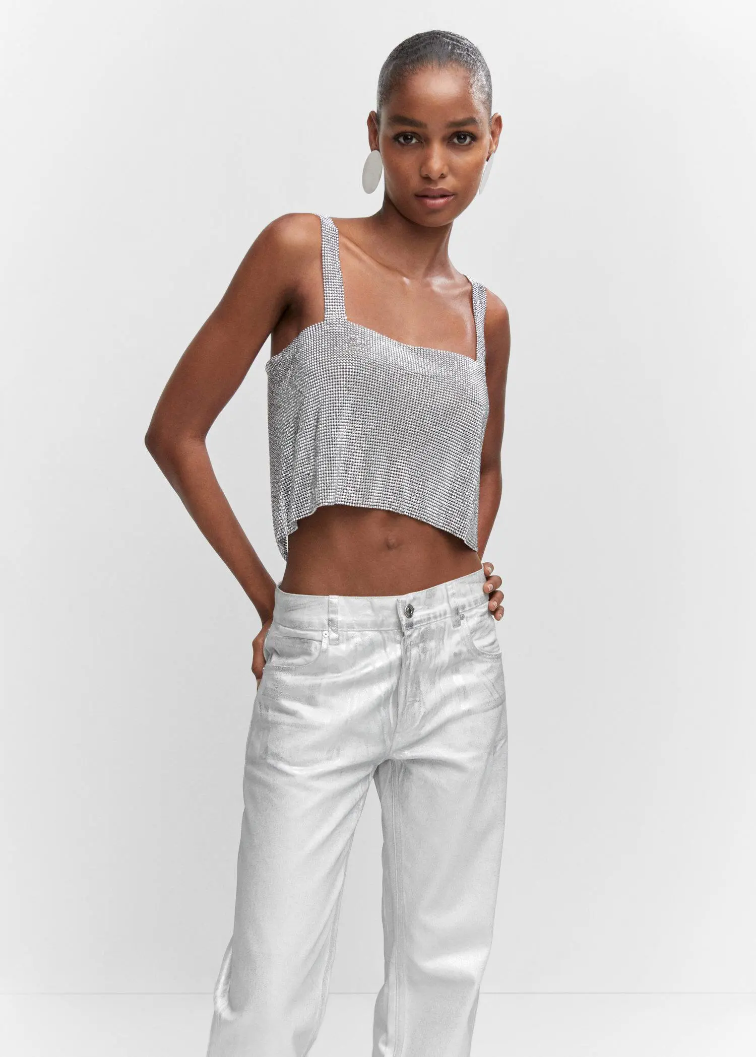 Mango Crystal mesh top. a woman wearing white pants and a silver top. 