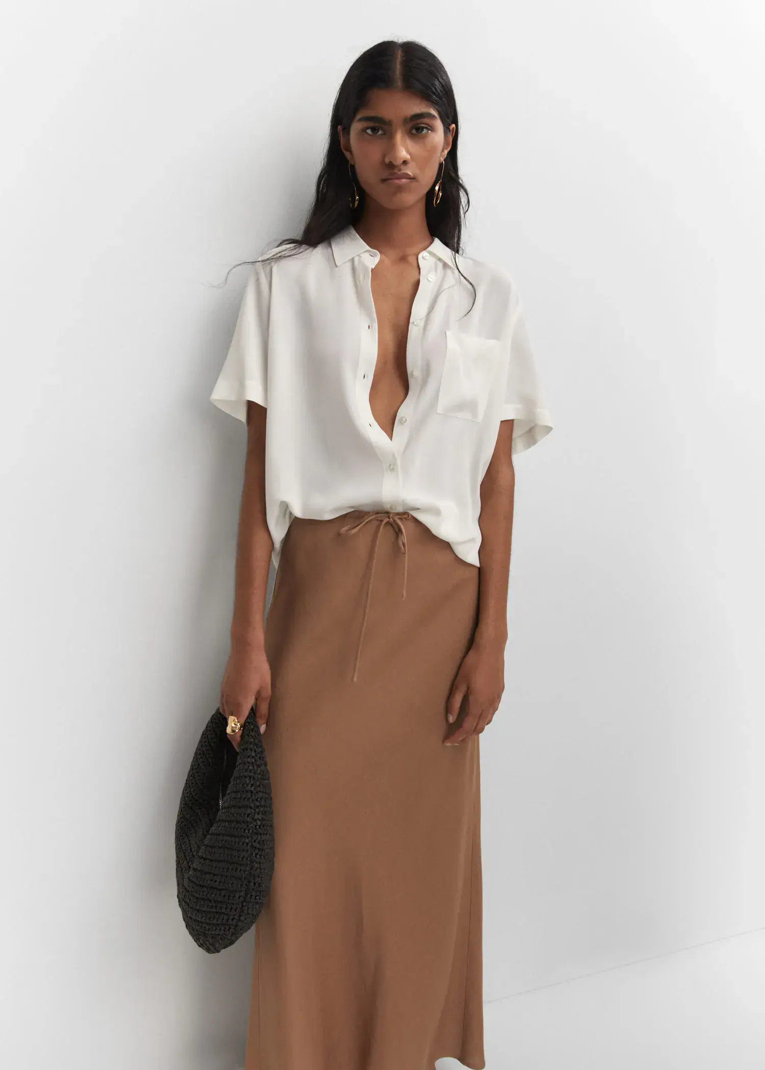 Mango Pocket oversize shirt. a woman wearing a white shirt and a brown skirt. 