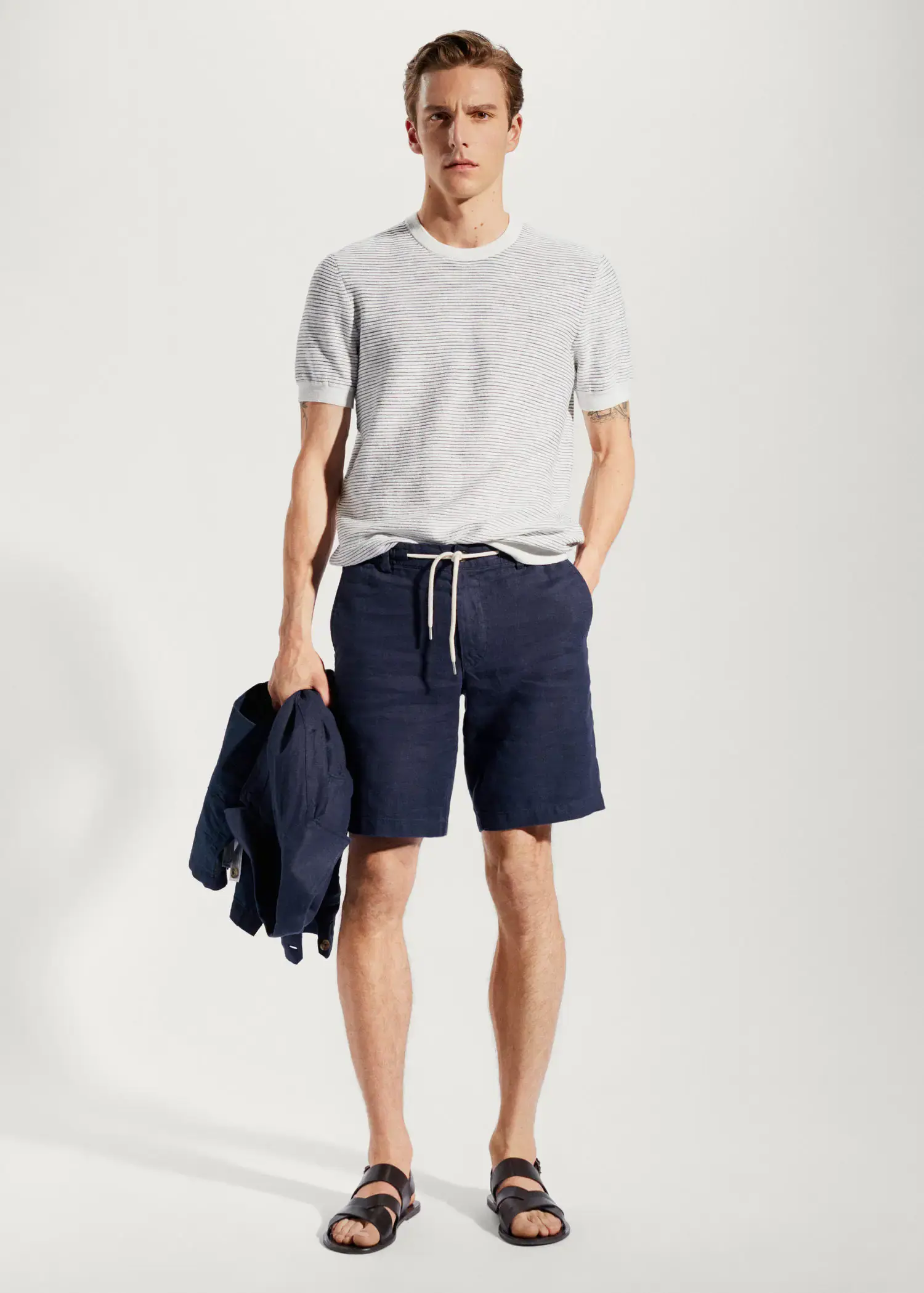 Mango 100% linen bermuda shorts with drawstring. a young man in shorts and a white shirt. 