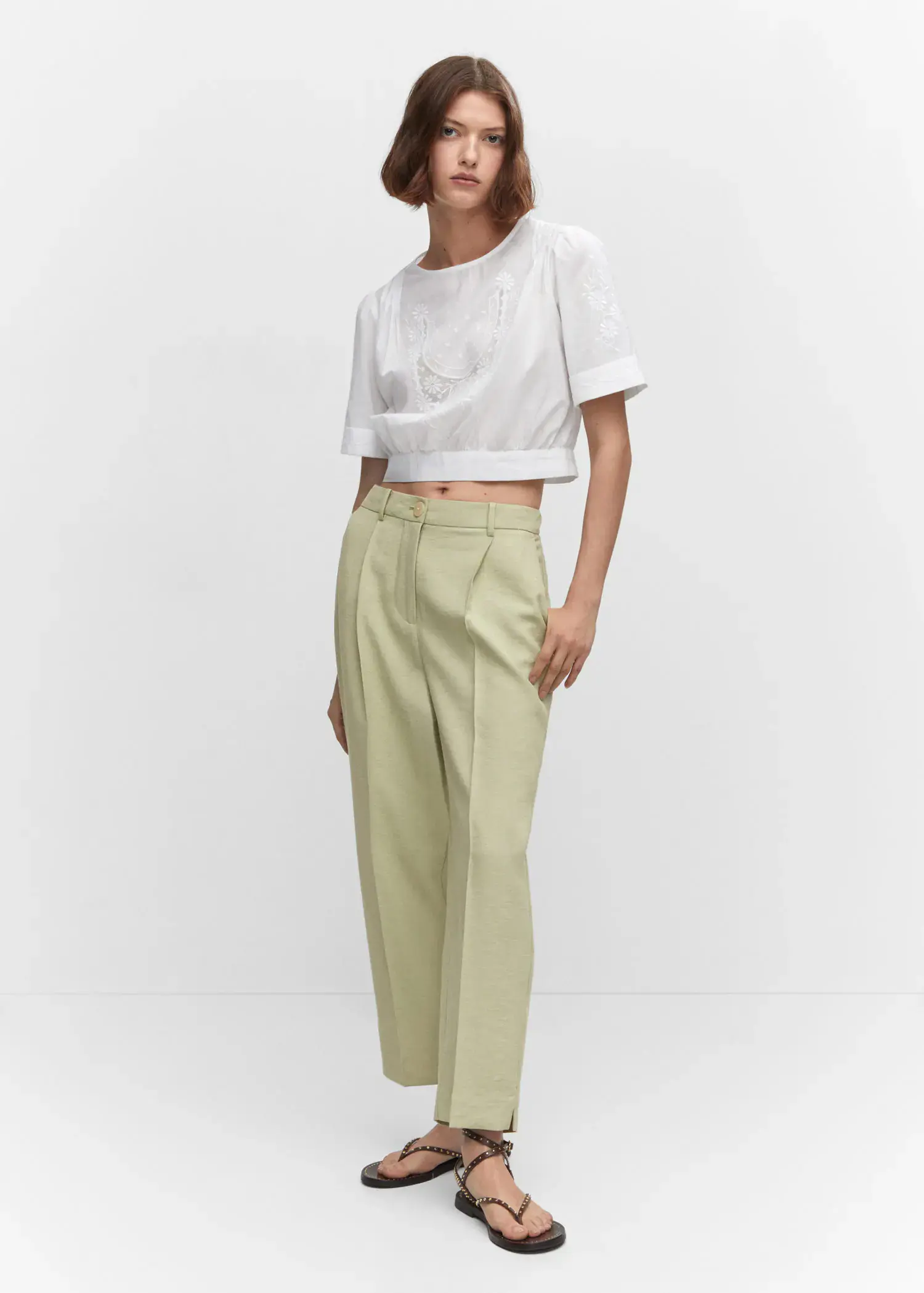 Mango Pleat straight trousers. a person standing in a room wearing a white shirt and green pants. 