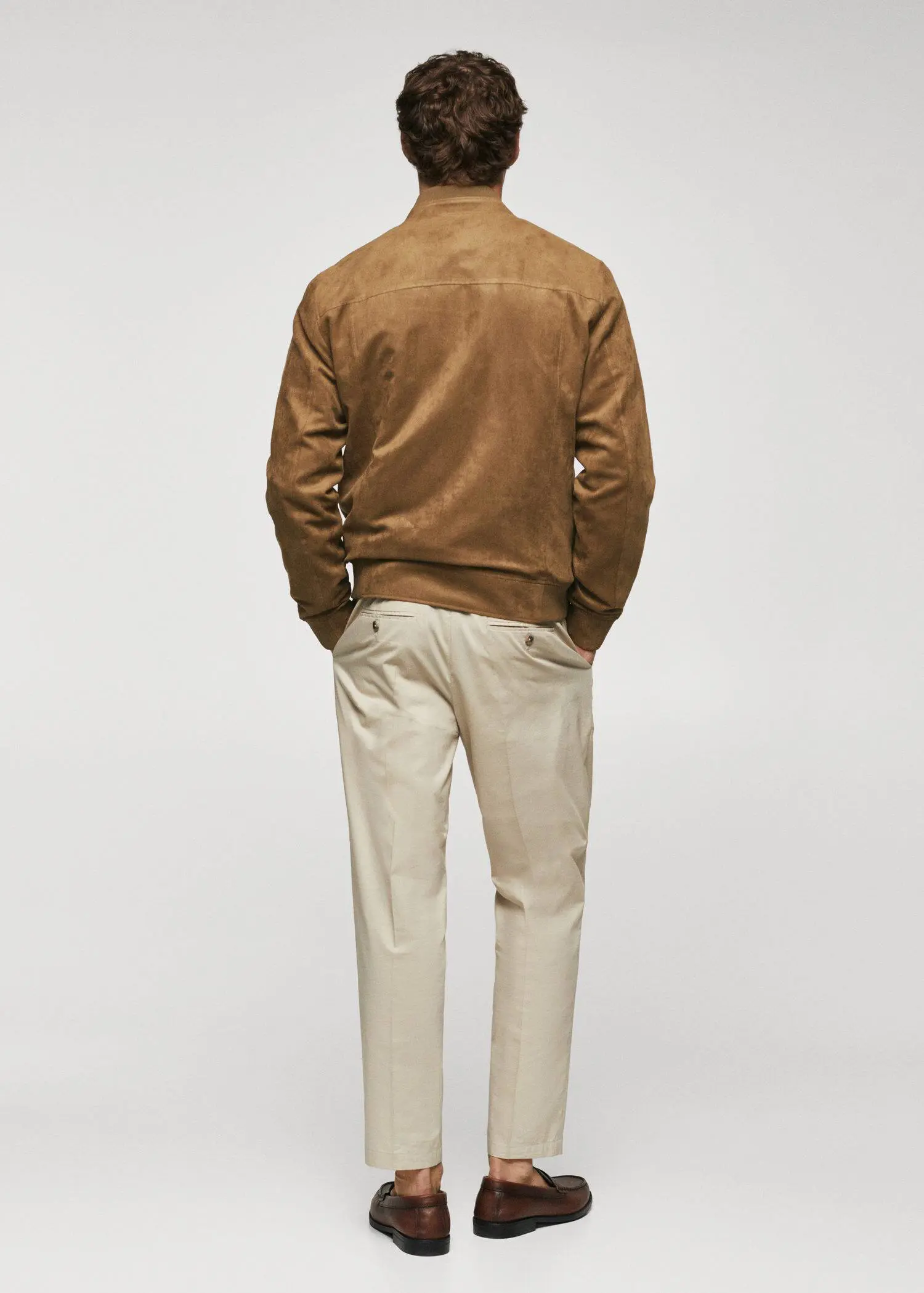 Mango Suede-effect bomber jacket. a man in a brown jacket and white pants. 
