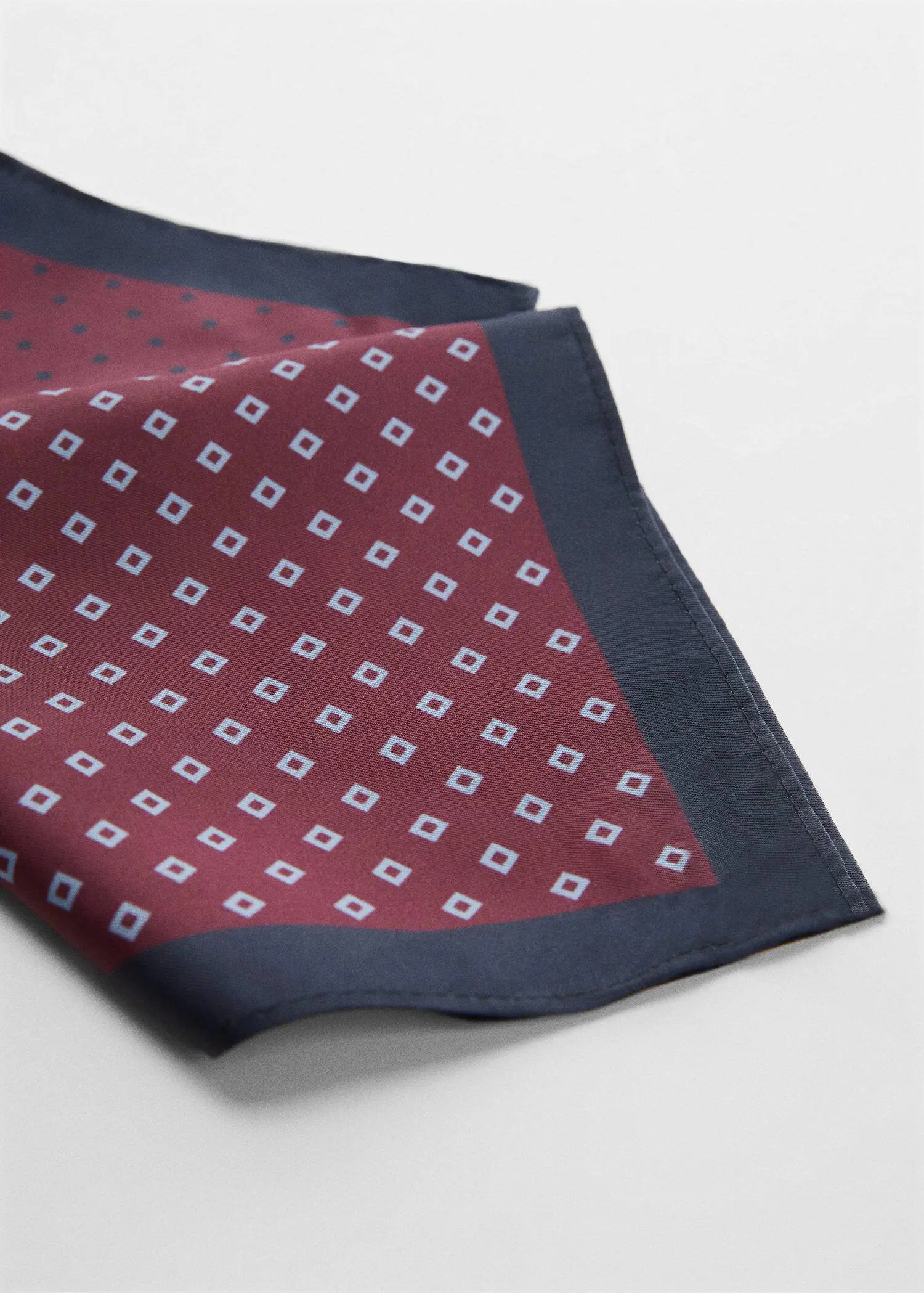 Mango Printed pocket square. a close-up of a red and white square patterned pocket square. 