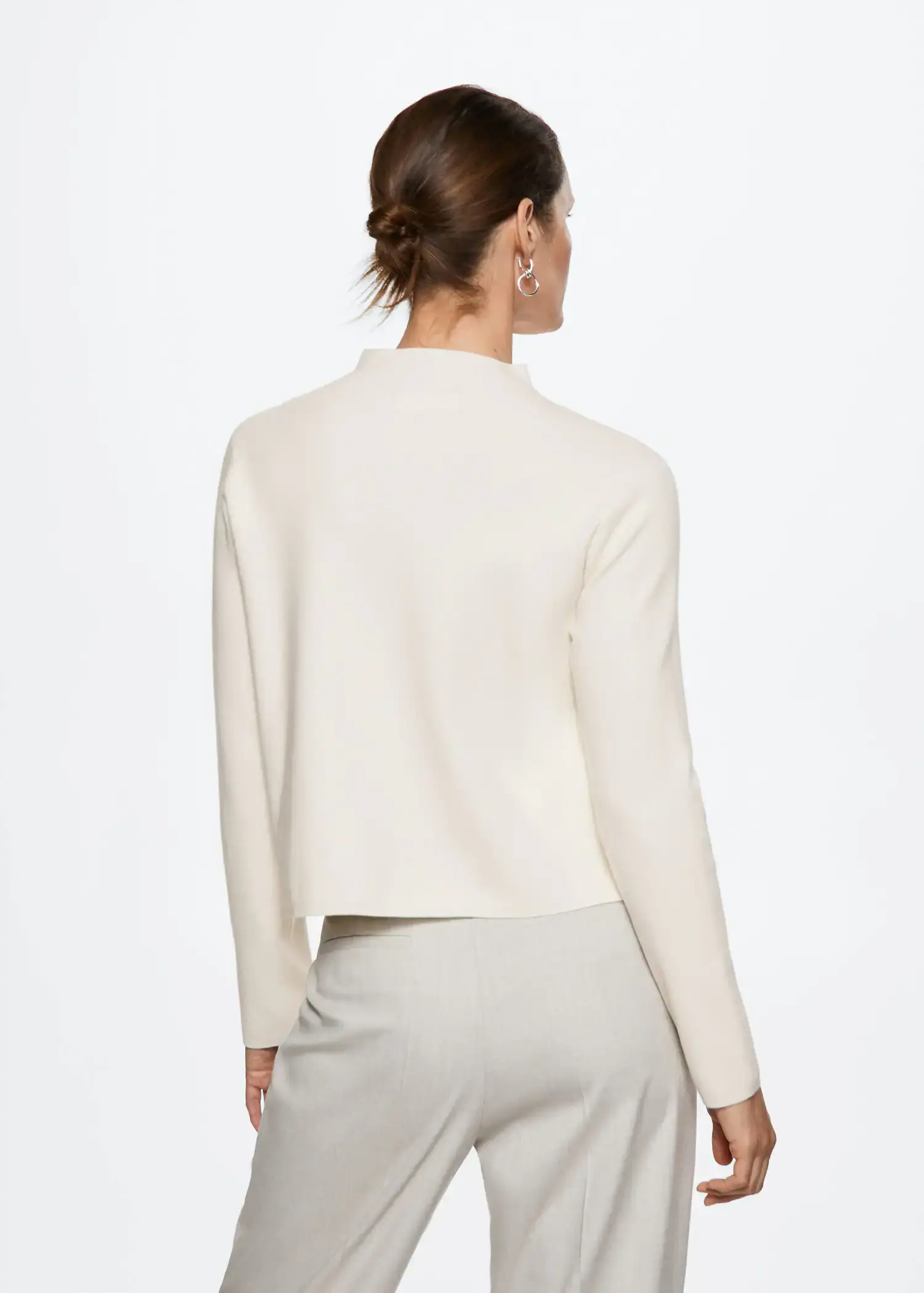 Mango High collar sweater. a woman wearing a white sweater standing in front of a white wall. 