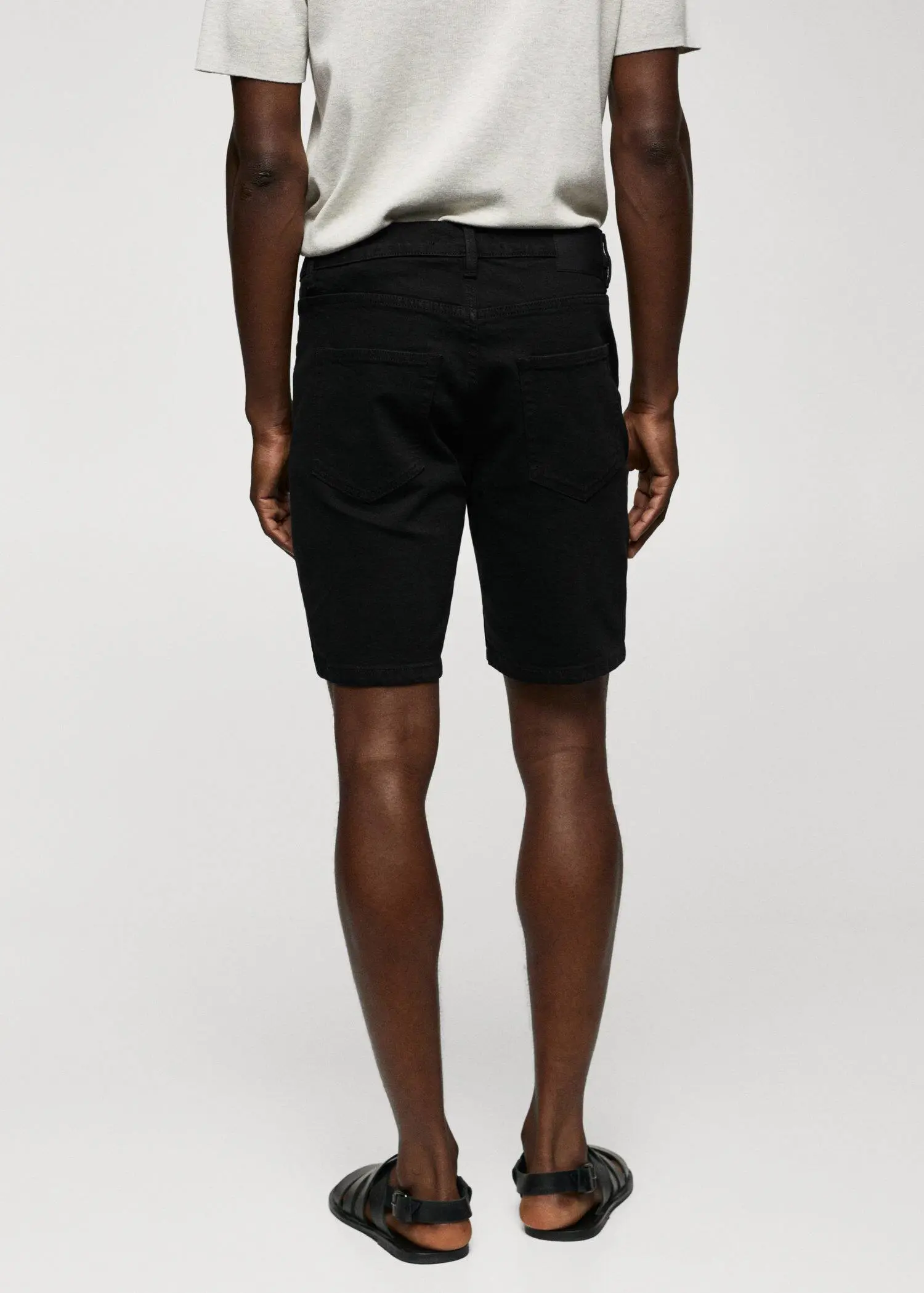 Mango Regular-fit denim bermuda shorts. a man in black shorts and a white t shirt. 