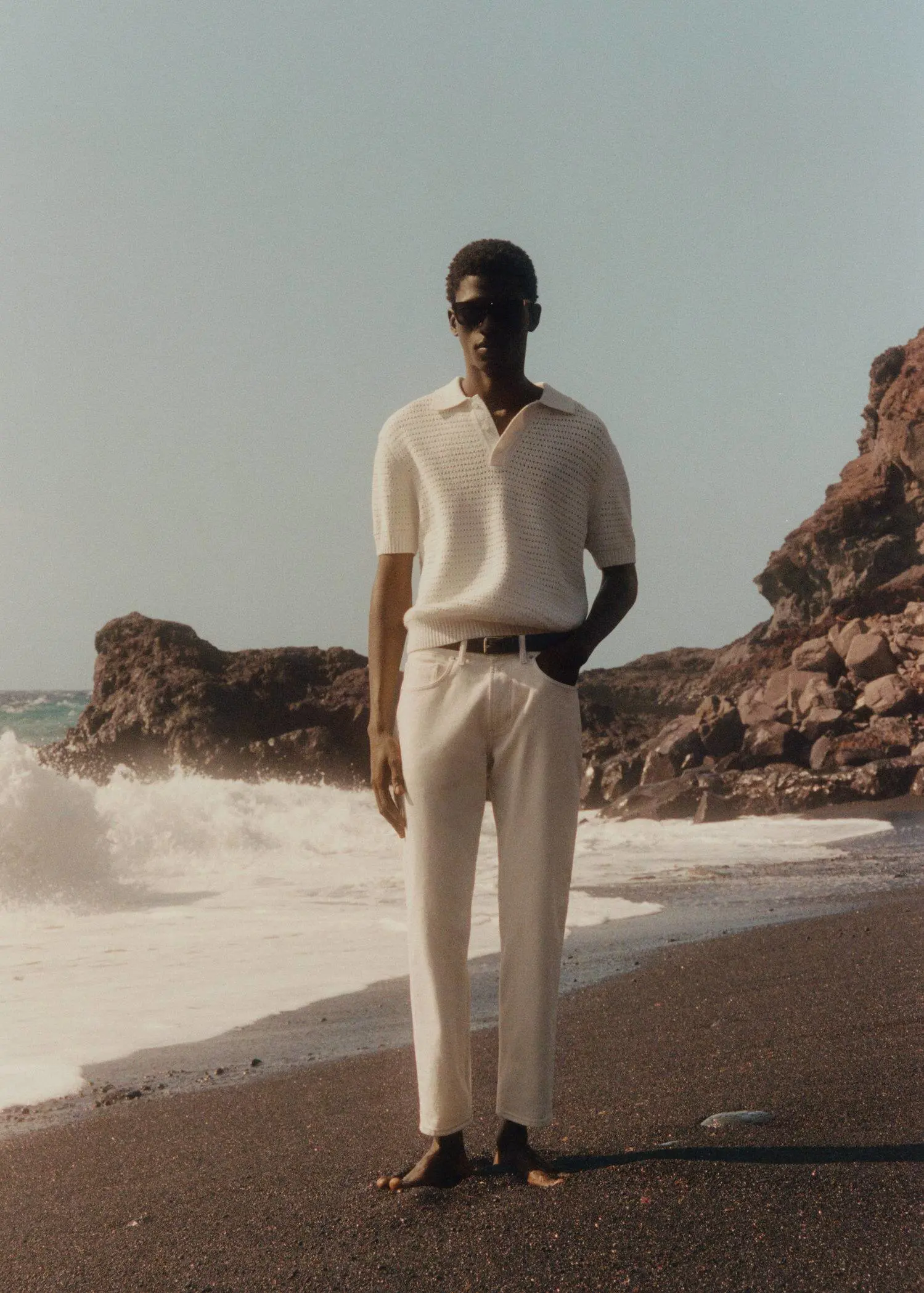 Mango Ben tapered cropped jeans. a man standing on the beach wearing a white shirt. 