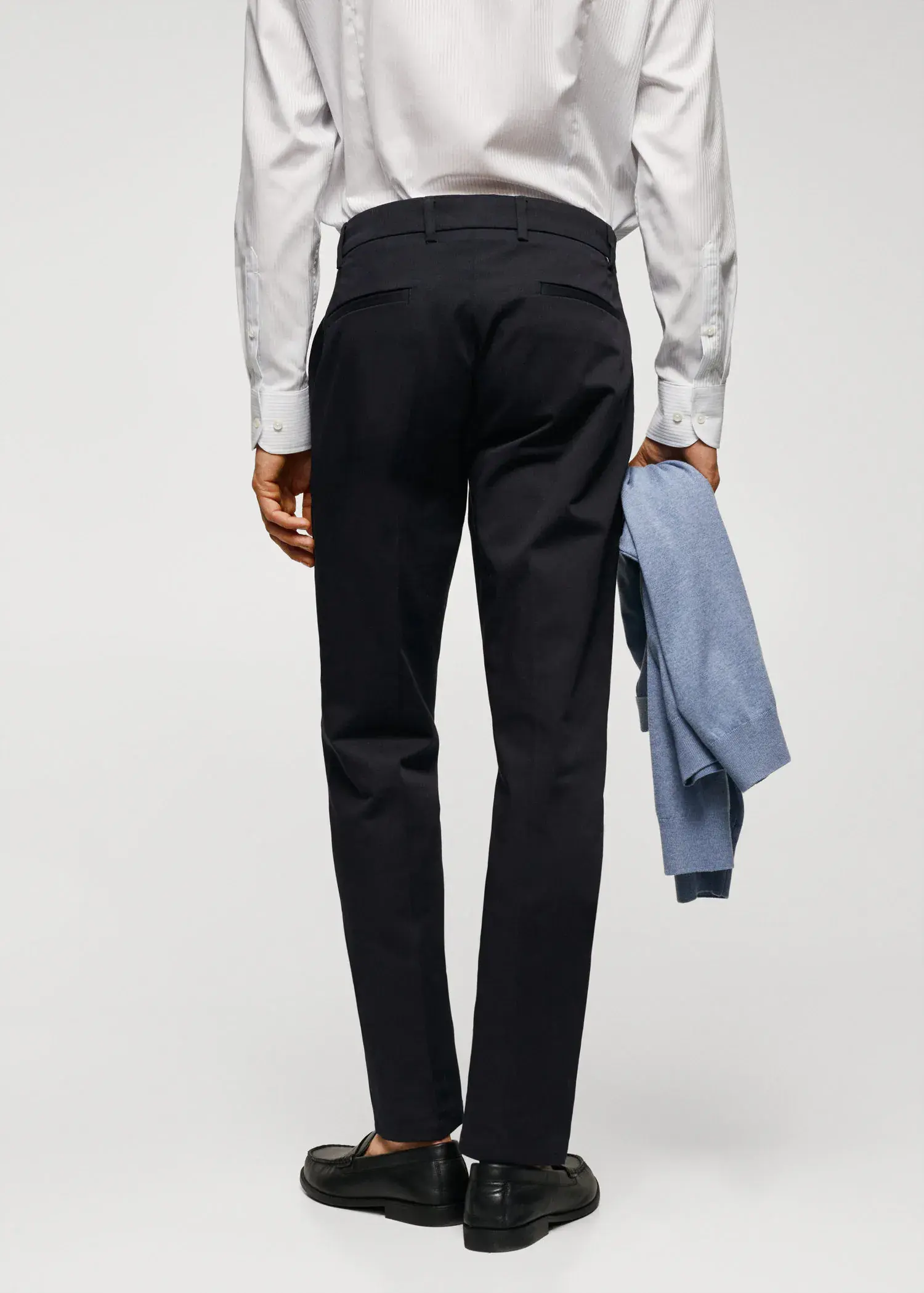 Mango Slim fit chino trousers. a man in a white dress shirt and black pants holding a jacket. 
