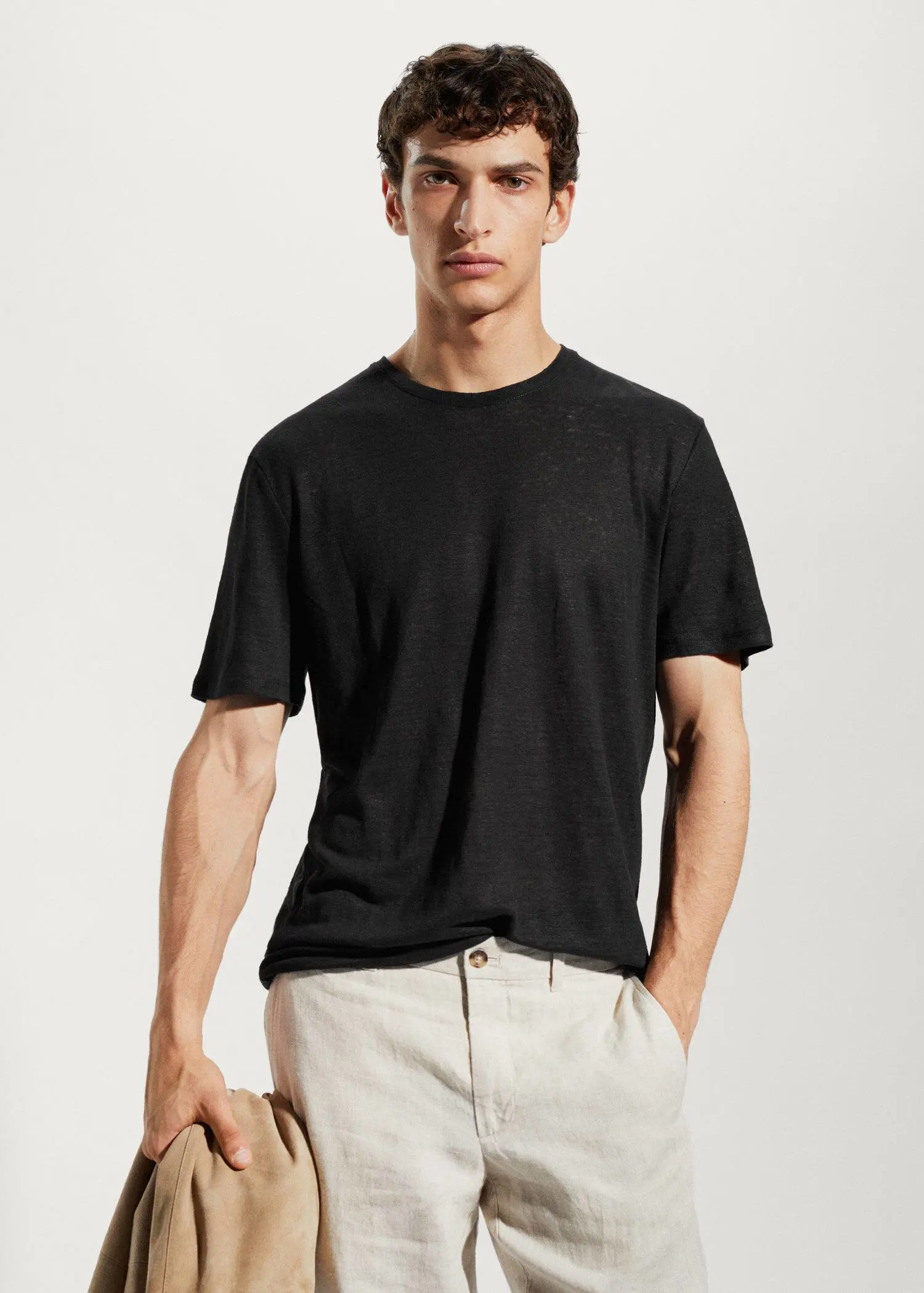 Mango 100% linen slim-fit t-shirt. a man wearing a black shirt and white pants. 