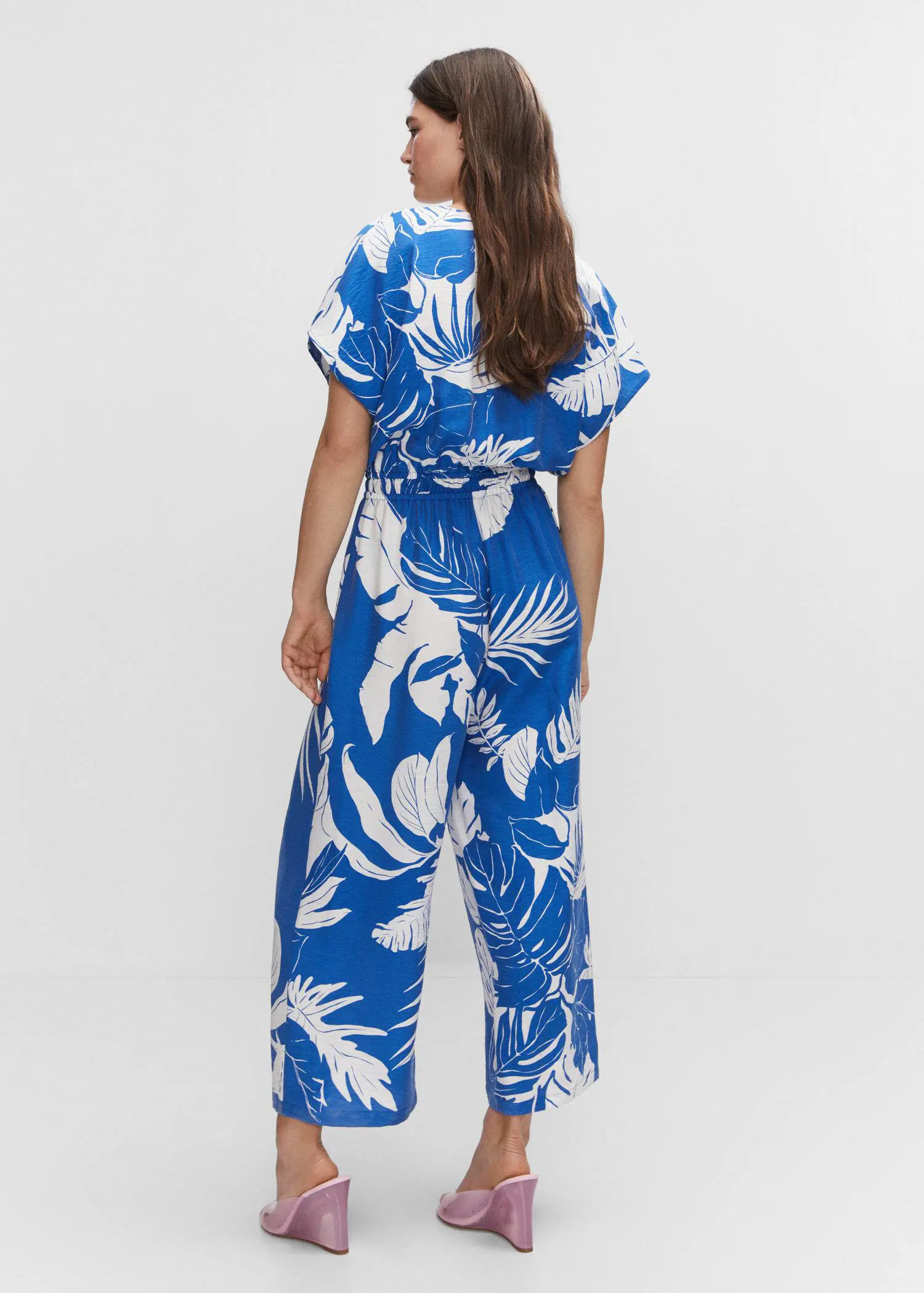 Mango Tropical print jumpsuit. a woman wearing a blue and white floral jumpsuit. 