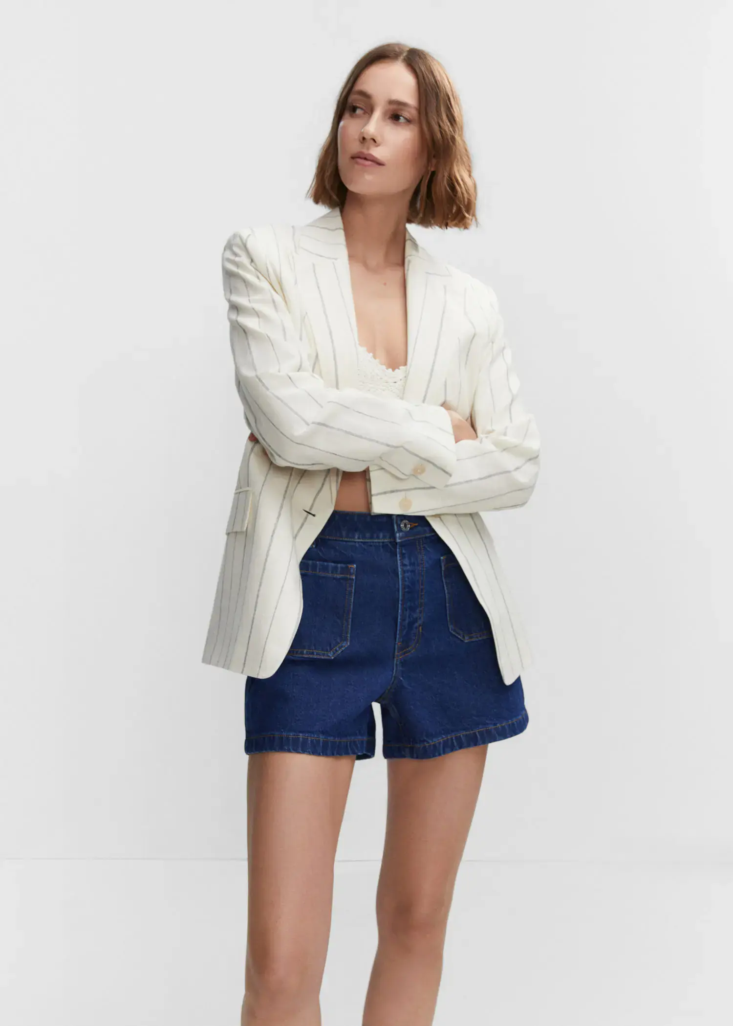 Mango Denim shorts with pockets. a woman wearing a white jacket and blue shorts. 