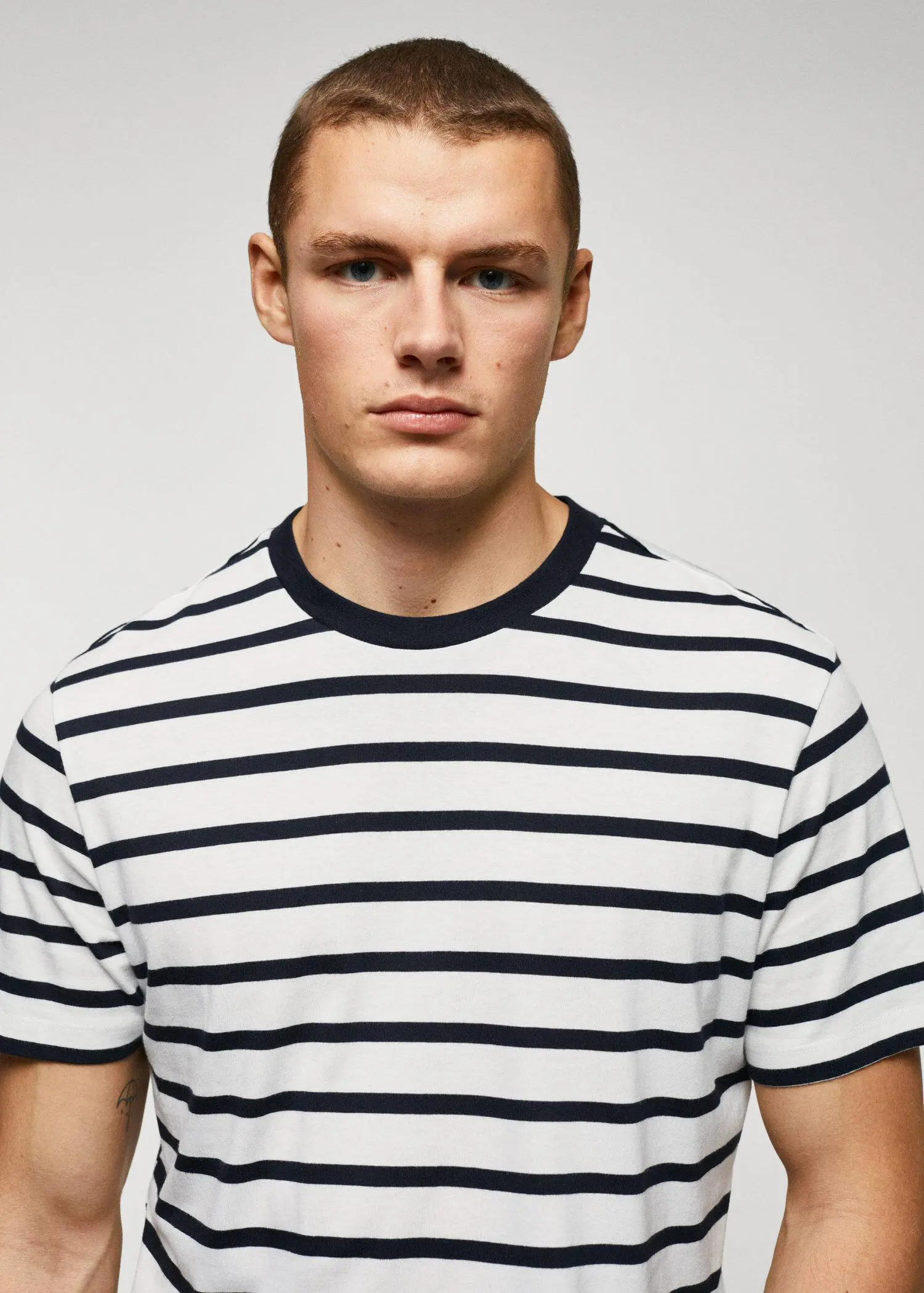 Mango Cotton-modal striped t-shirt. a young man wearing a striped t-shirt. 