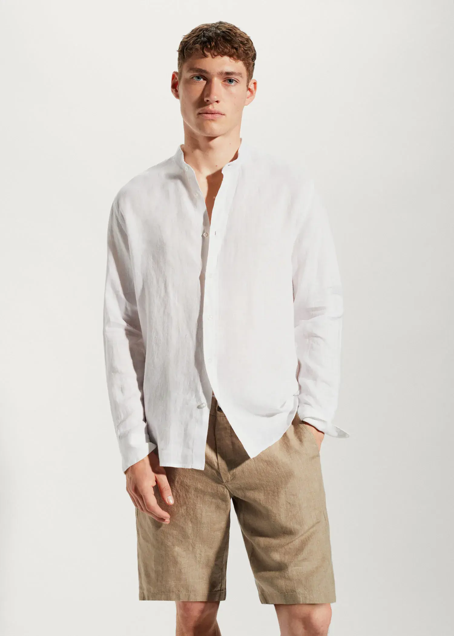 Mango 100% linen Mao collar shirt. a man wearing a white shirt and brown pants. 