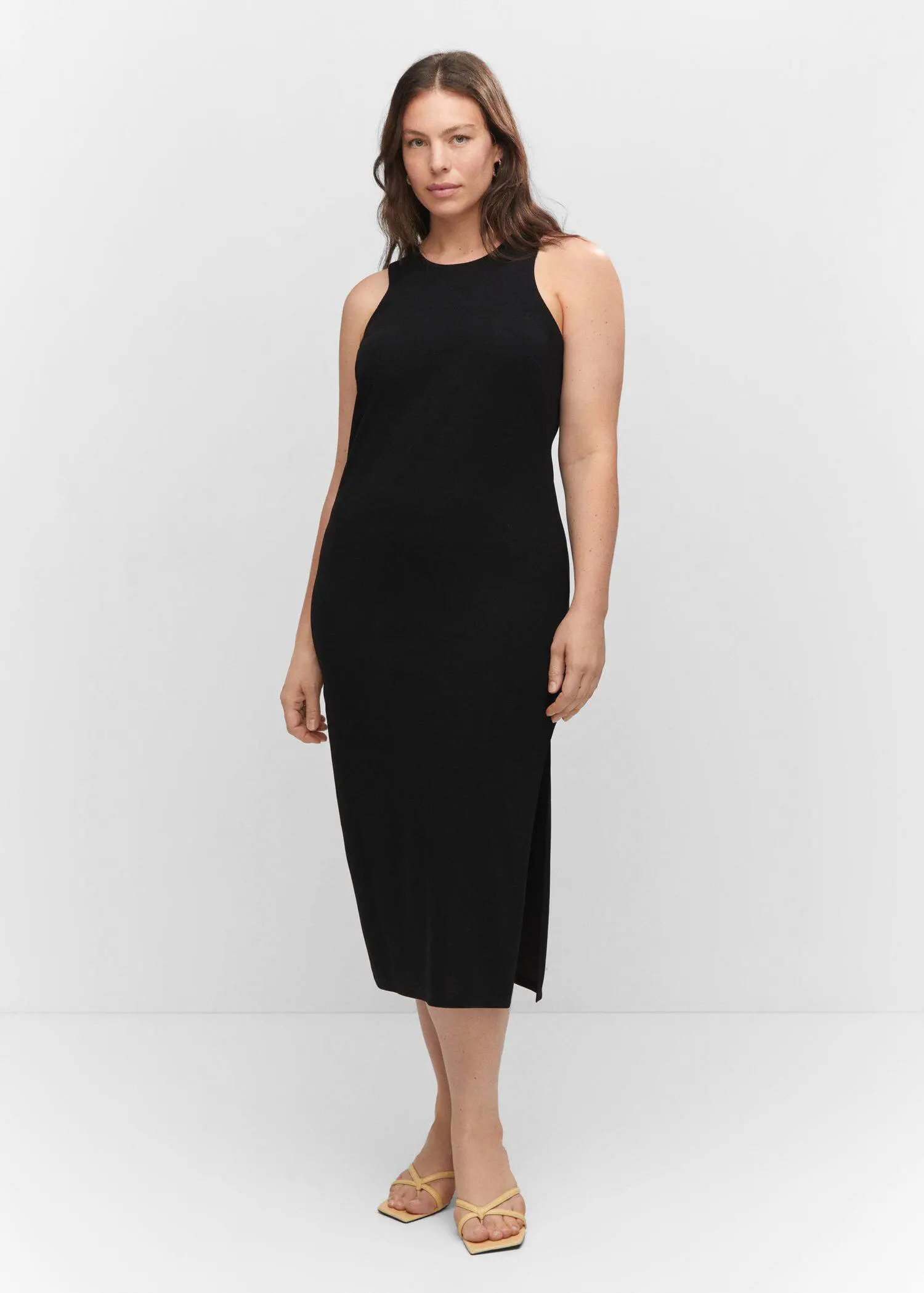 Mango Midi-dress with slit. a woman in a black dress is posing. 
