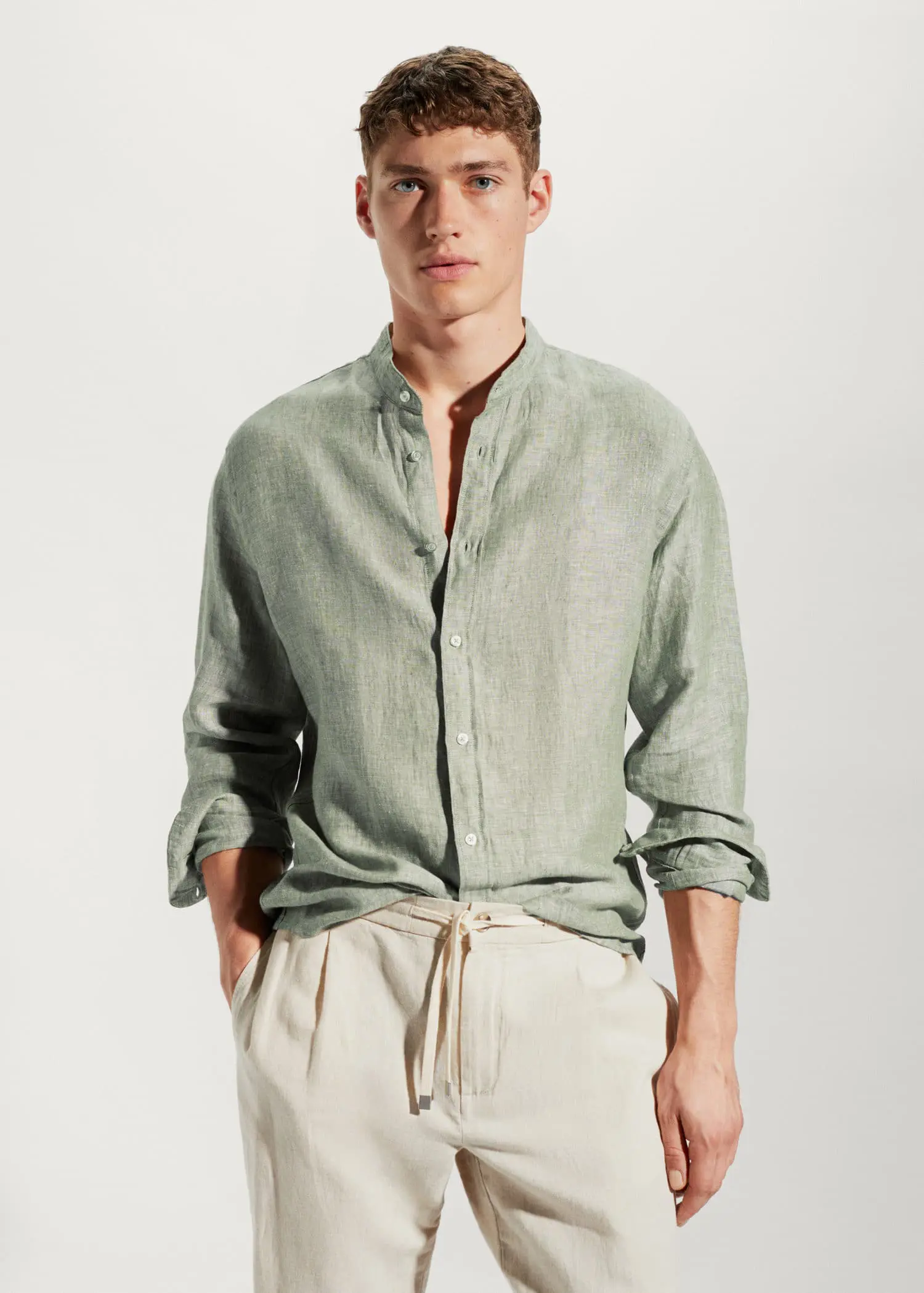 Mango 100% linen Mao collar shirt. a man wearing a green shirt and white pants. 